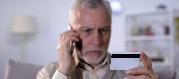 Old man holds credit card