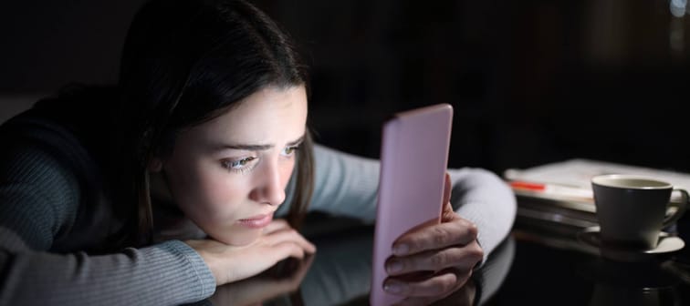 Sad female checking smart phone content