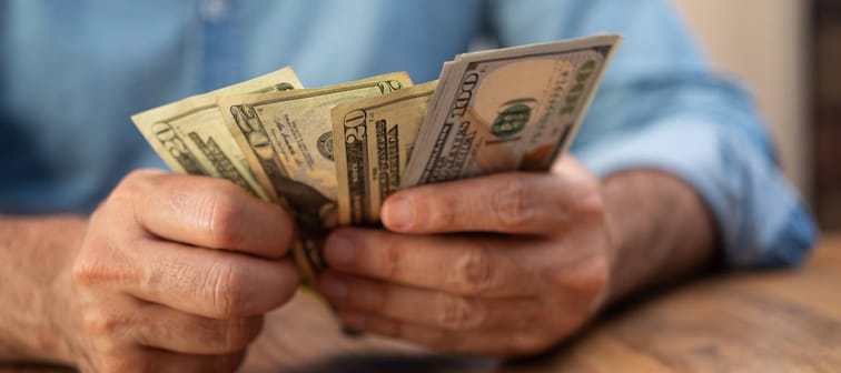 Close up of man's hands counting out American cash.