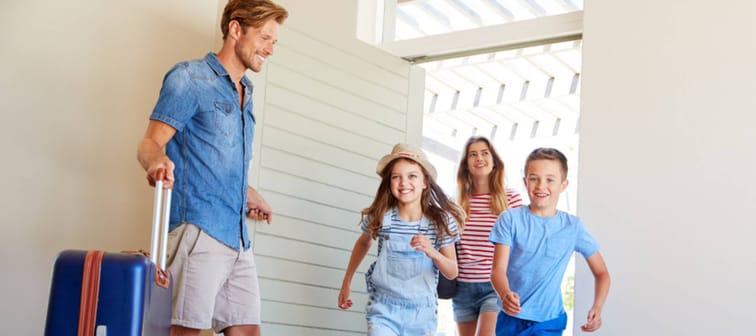 Family of four arriving at a vacation rental.