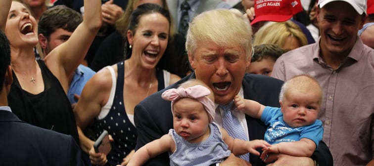 Donald Trump reacts as he holds of three-month-old Kellen Campbell, of Denver, right, while holding six-month-old Evelyn Keane, of Castle Rock, Colo., on July 29, 2016.