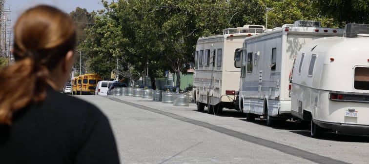 Woman standing across the street from RVs that house homeless people in LA.