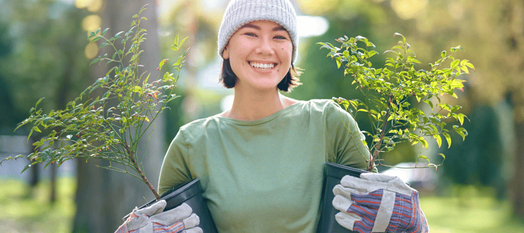 Woman portrait, plant and gardening in a park with trees in nature environment, agriculture or garden.