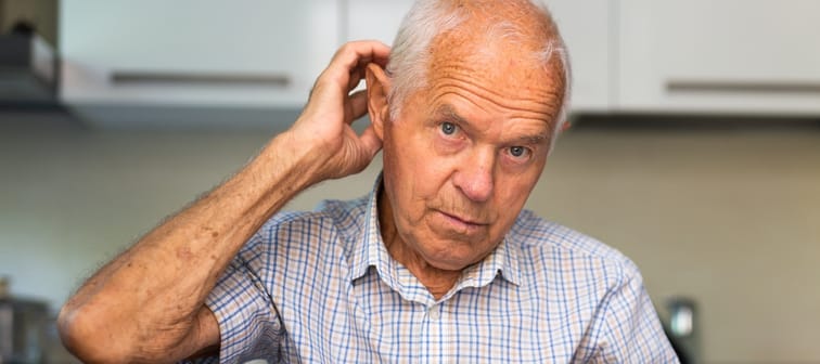 Man sitting at table at home calculating.