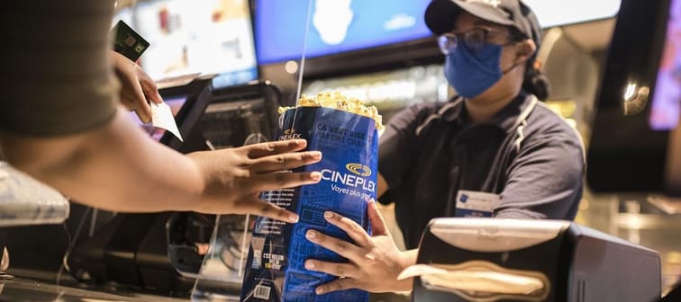 Cineplex Inc. reported a fourth-quarter loss $9 million compared with a profit of $10.2 million a year earlier as its revenue edged higher. A customer is served&nbsp;at a Cineplex theatre in 