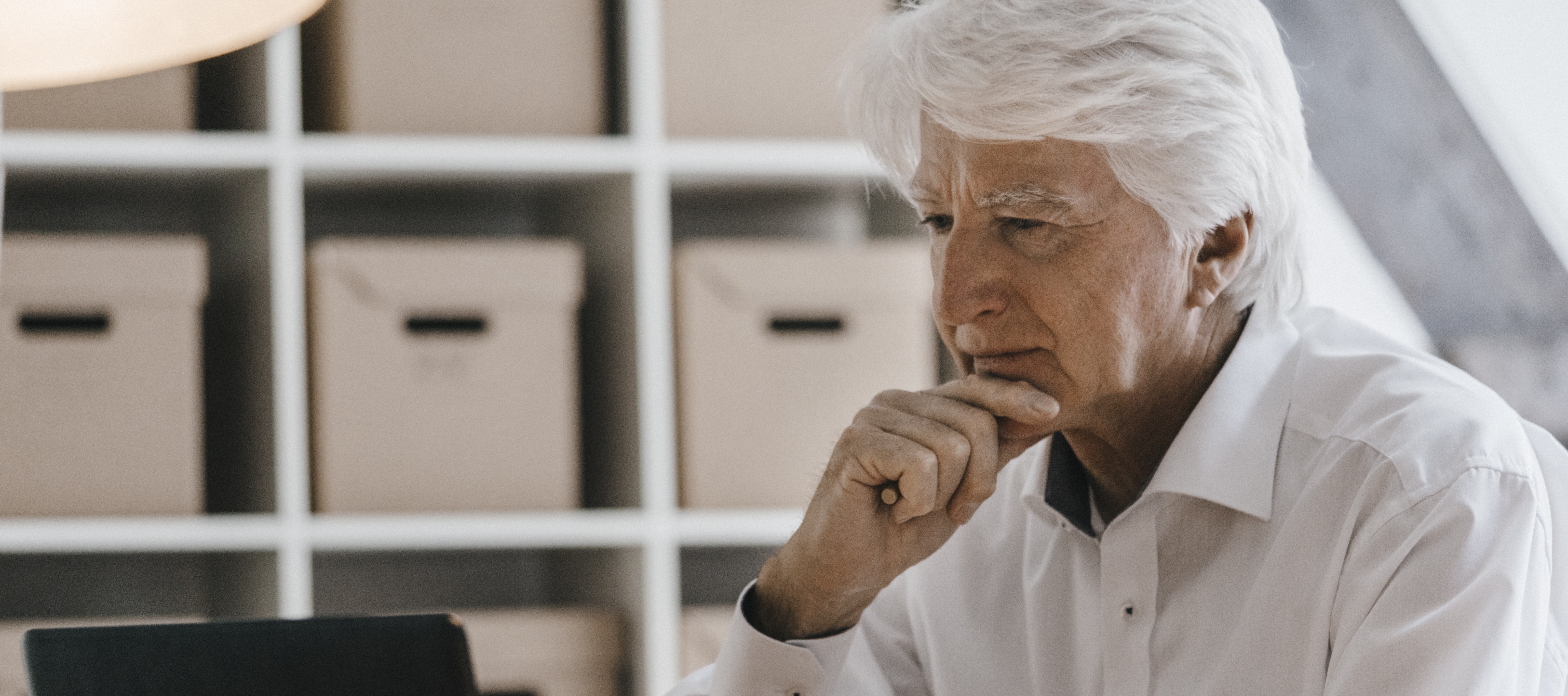 Older-aged male working on his laptop in a professional setting.