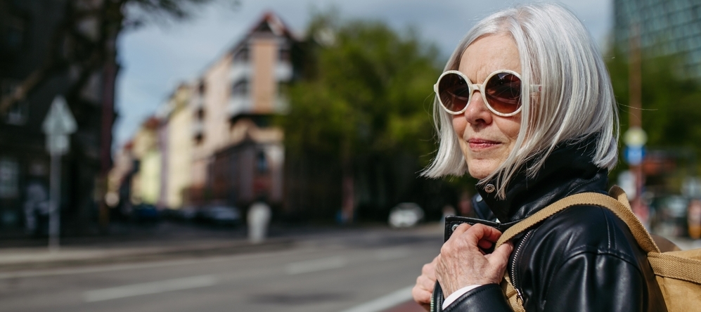 Portrait of stylish mature woman with gray hair on city street.