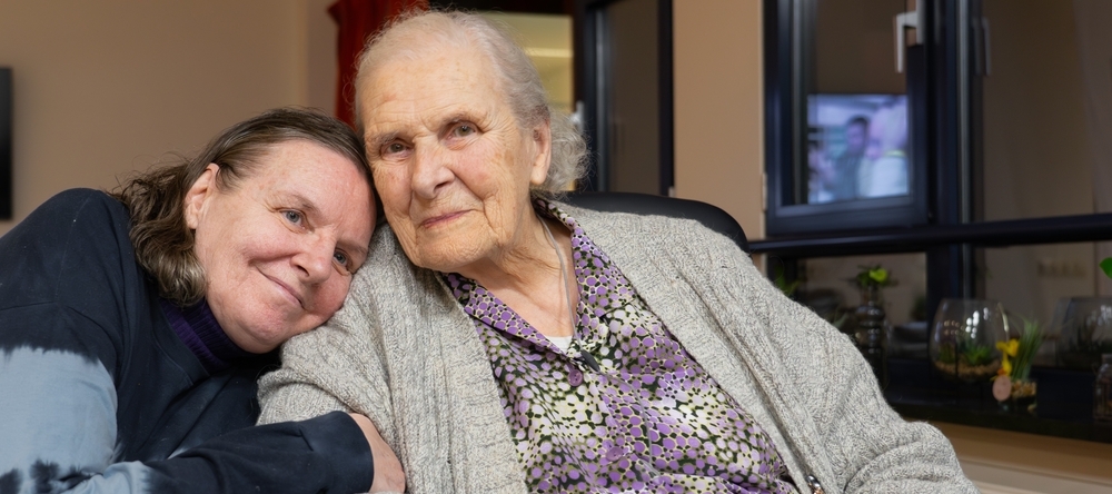 Elderly mother and daughter together on a visit to a nursing home.