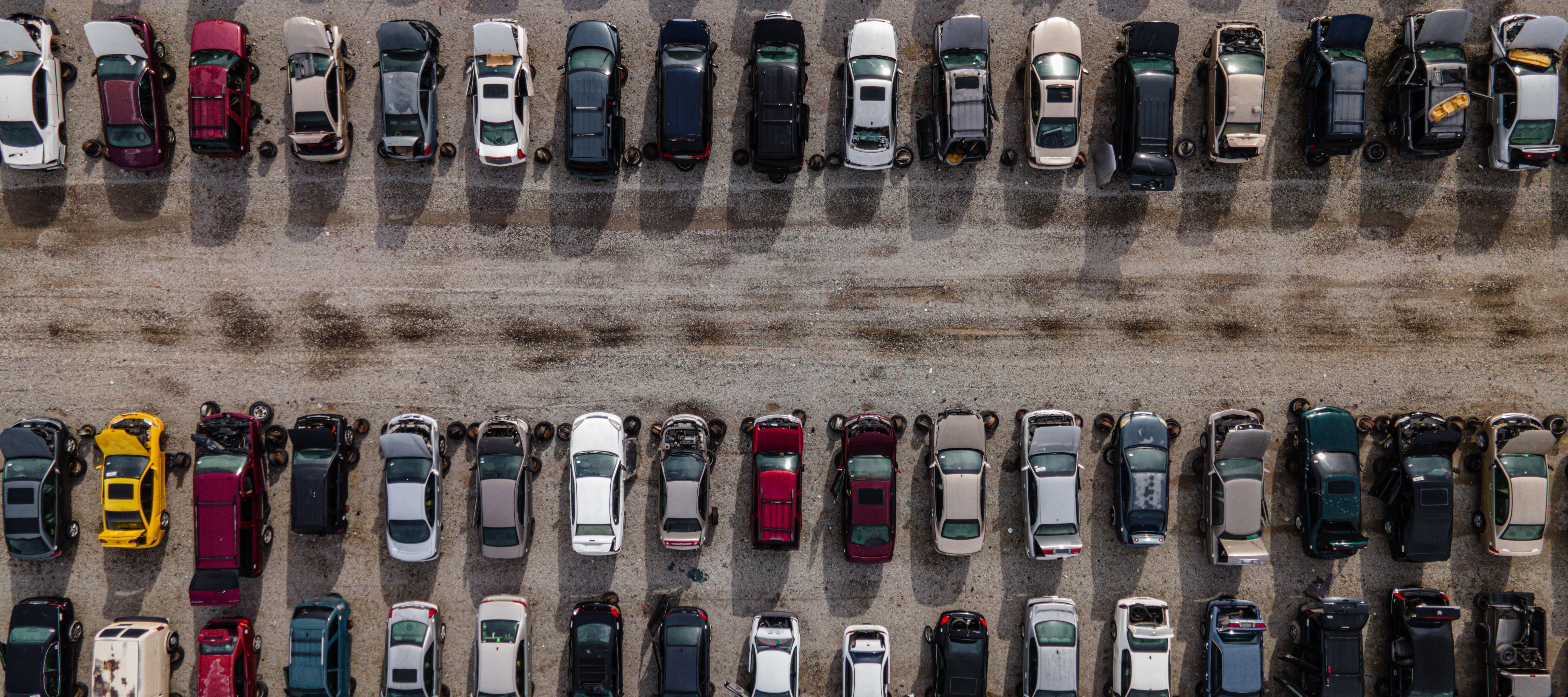 Aerial view of rows and rows of vehicles parked in large lot.