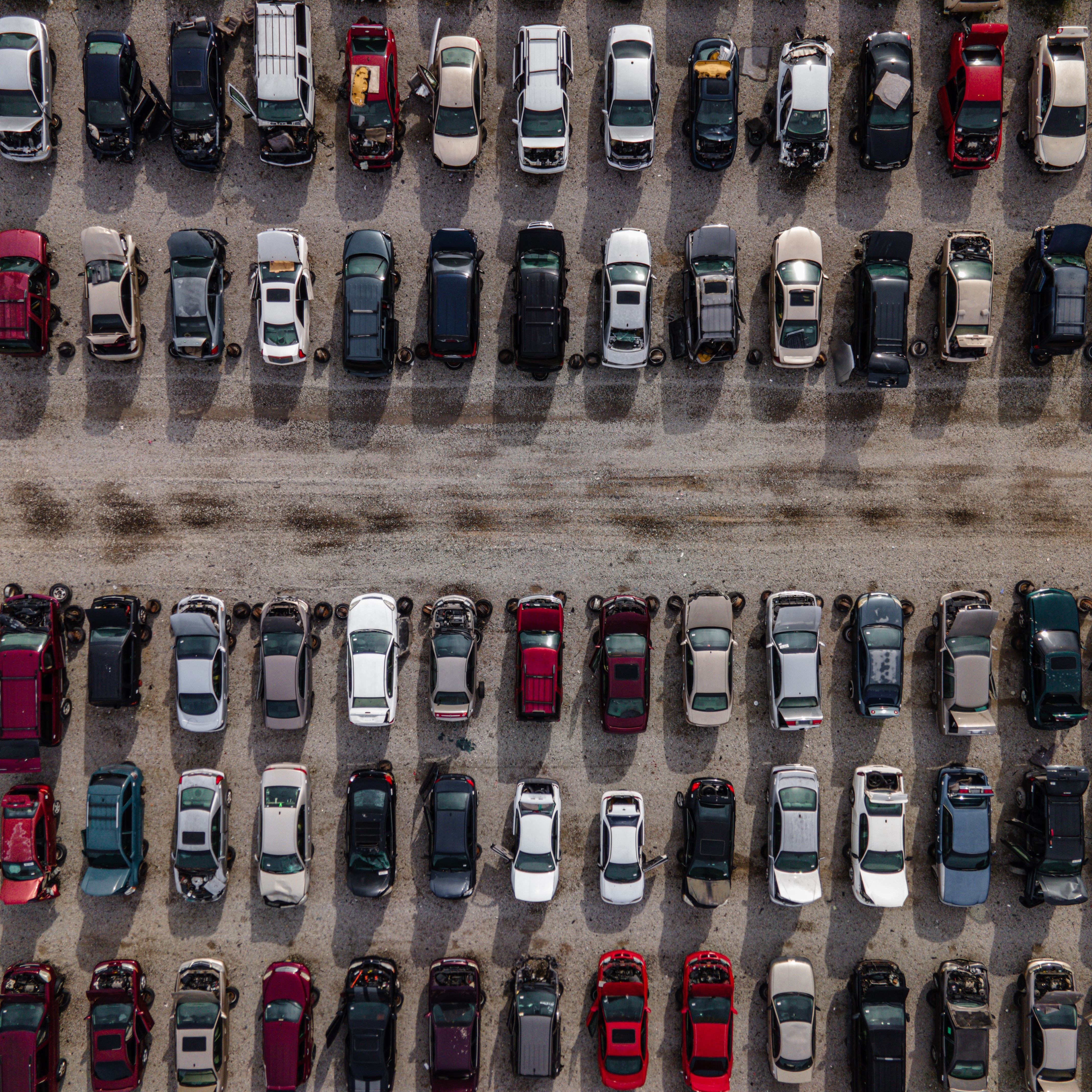 Aerial view of rows and rows of vehicles parked in large lot.