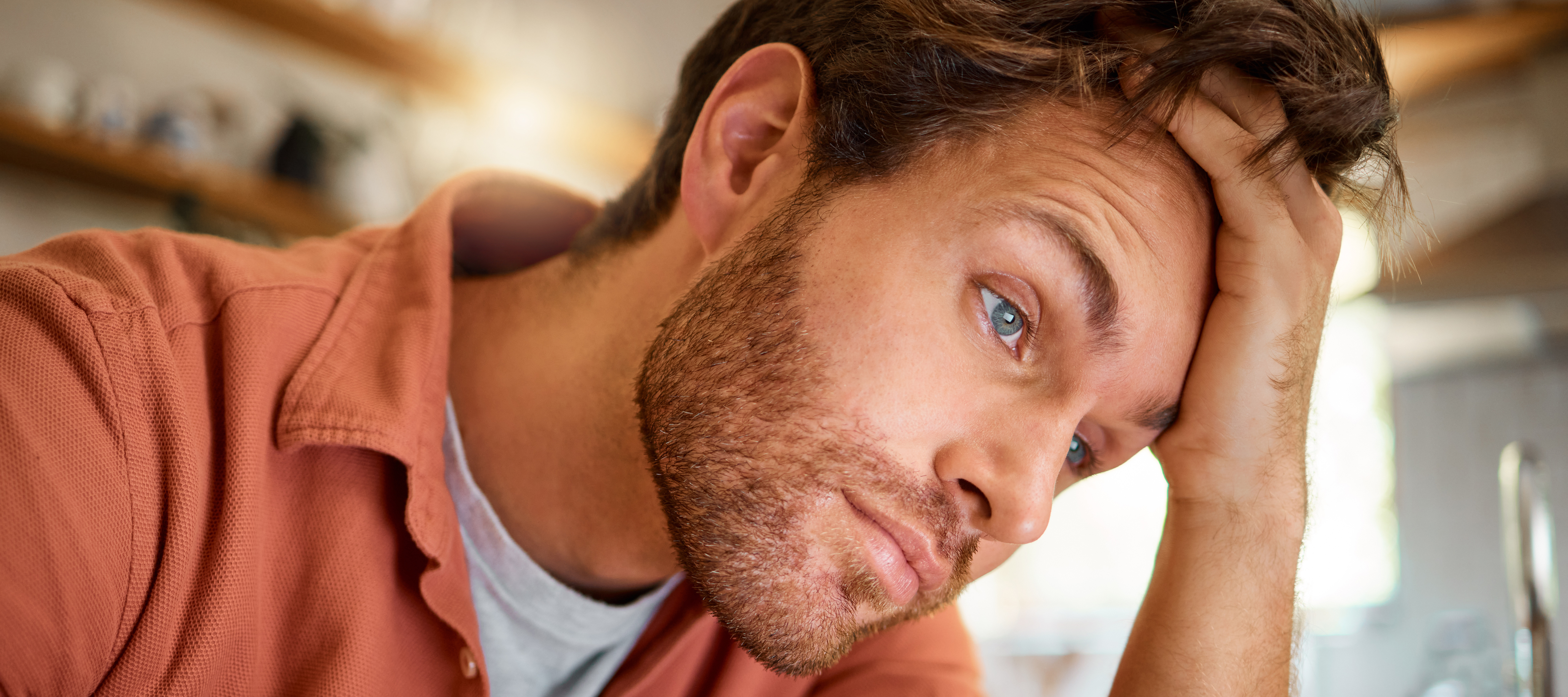 A homeowner appears to be stressed out in his kitchen.