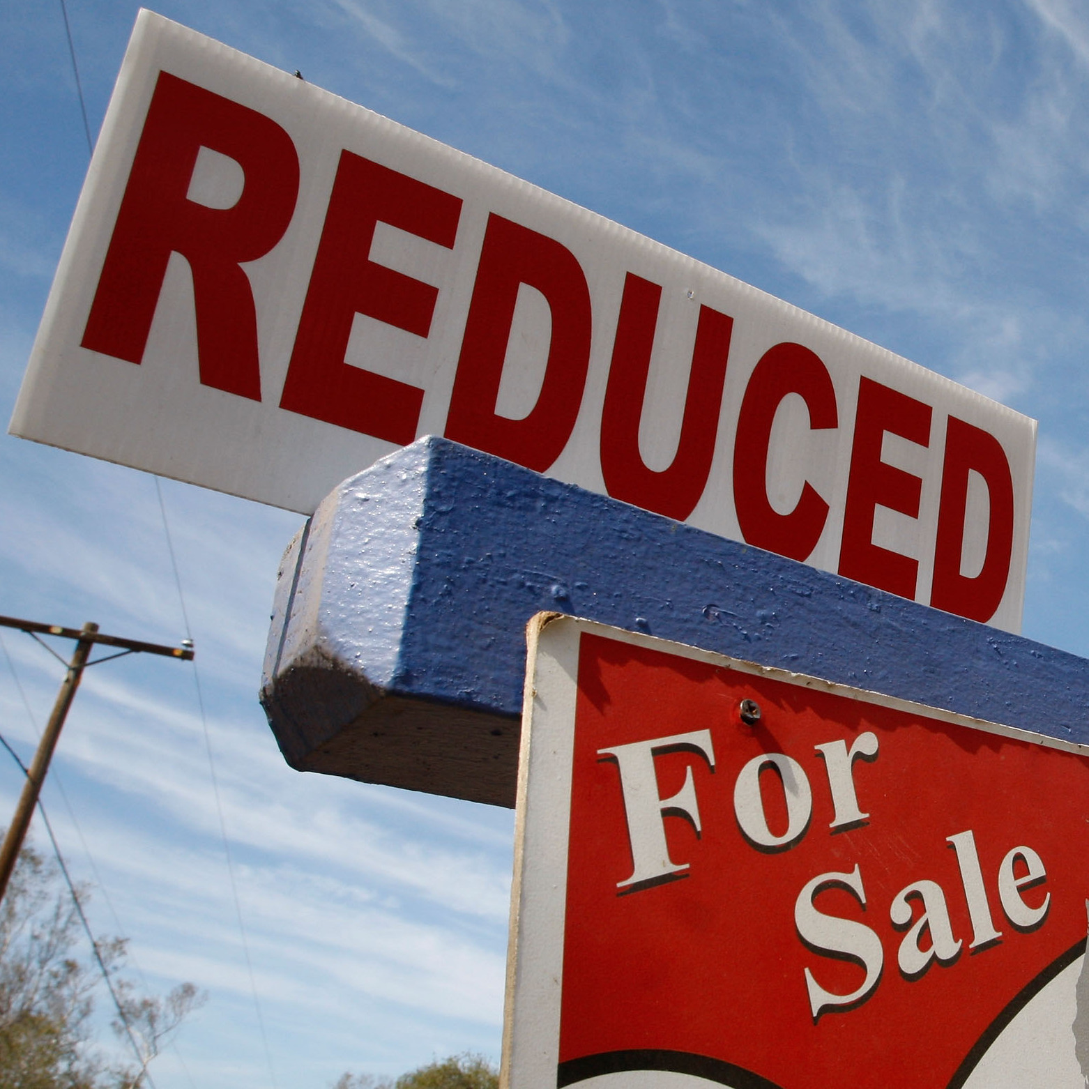A for sale sign indicates that a property's price tag has been reduced.