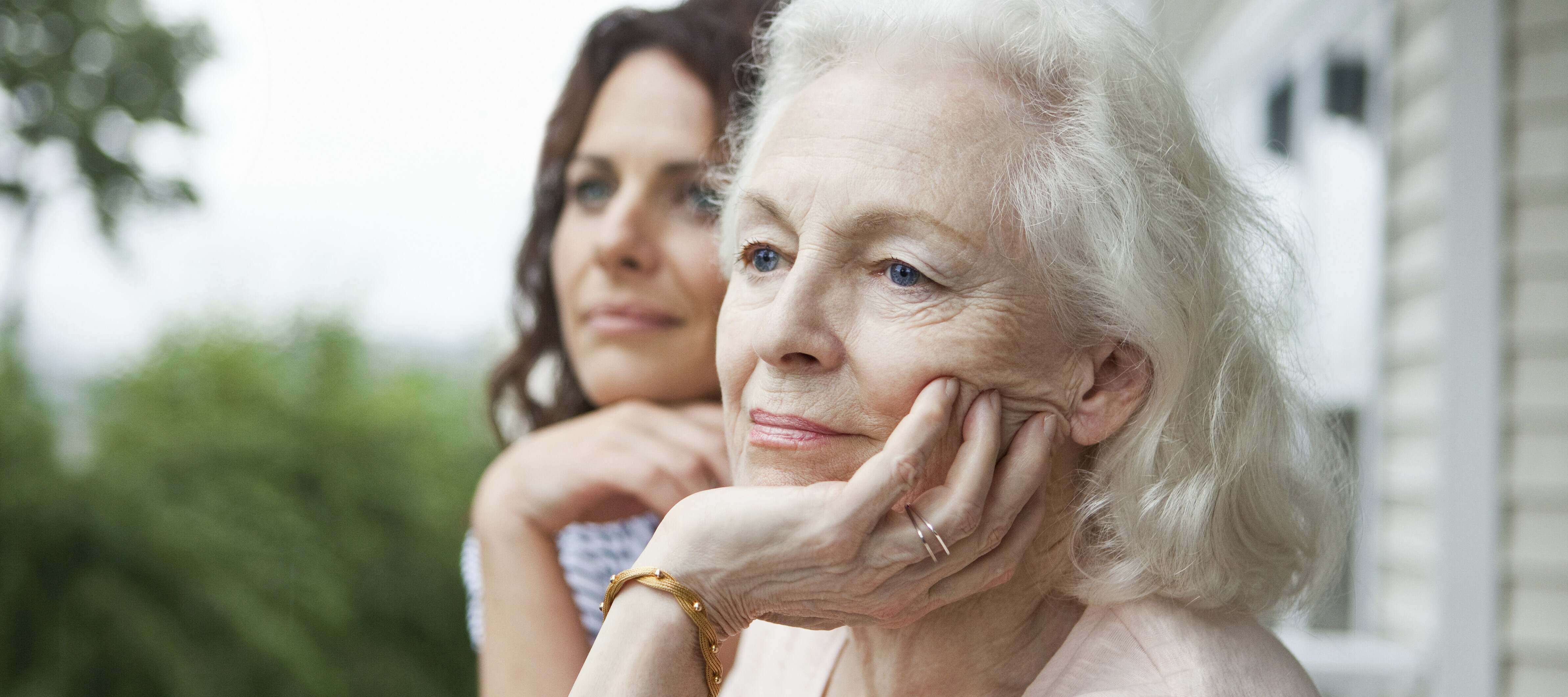 Older woman pondering her retirement next to her adult daughter.