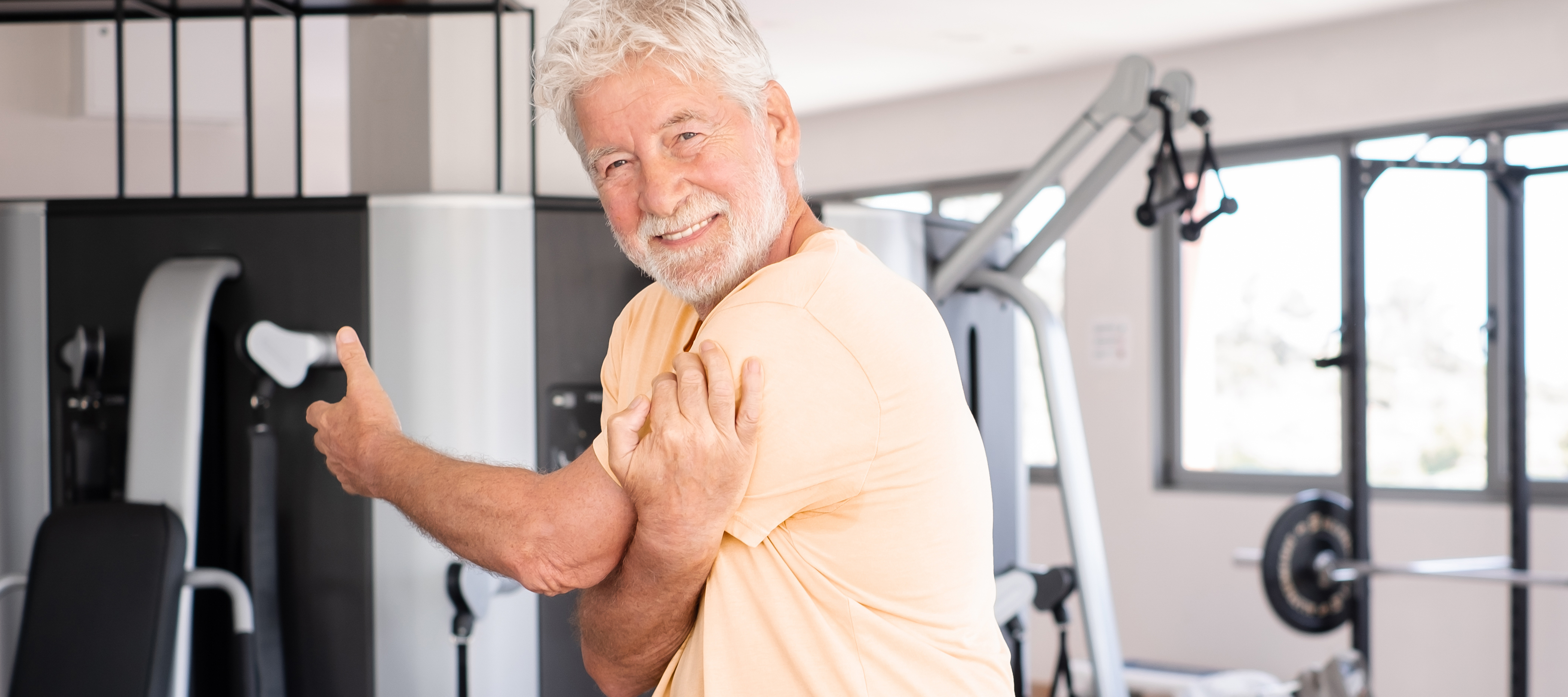 Retired man stretching in his home gym.