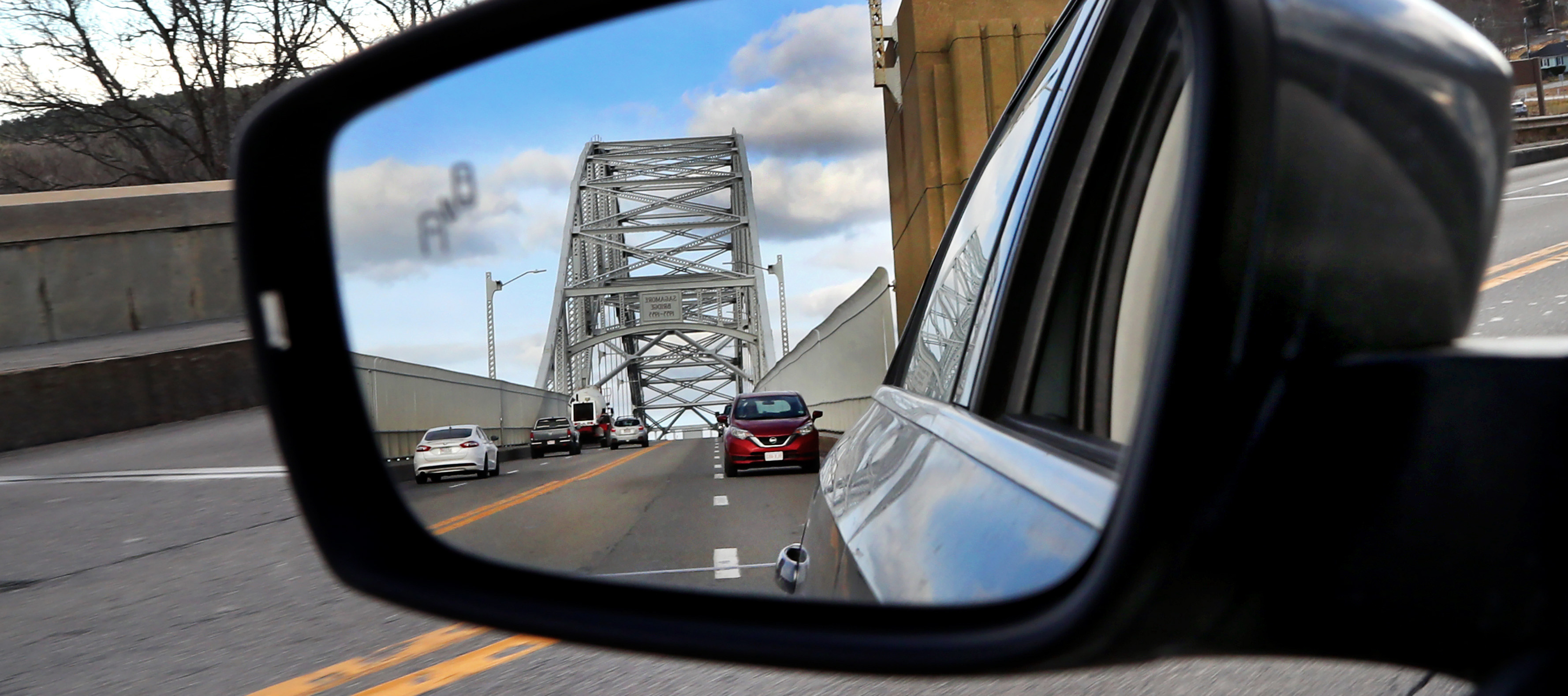 A rearview mirror image displaying the Sagamore Bridge in Massachusetts.