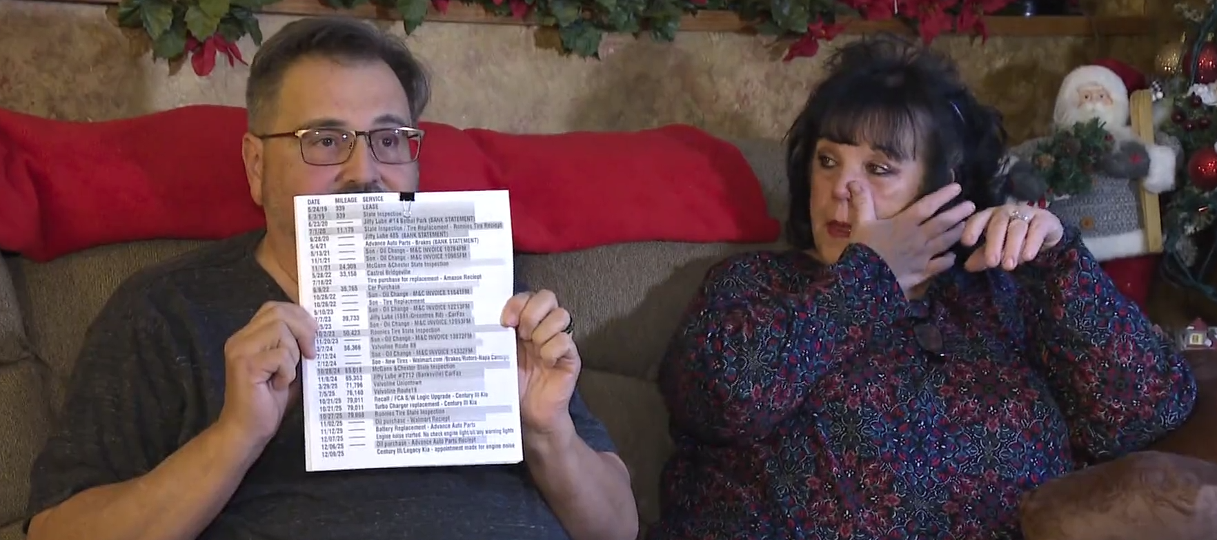 Jamie Rekasie holds up a record of all the maintenance work that's been done on his car.