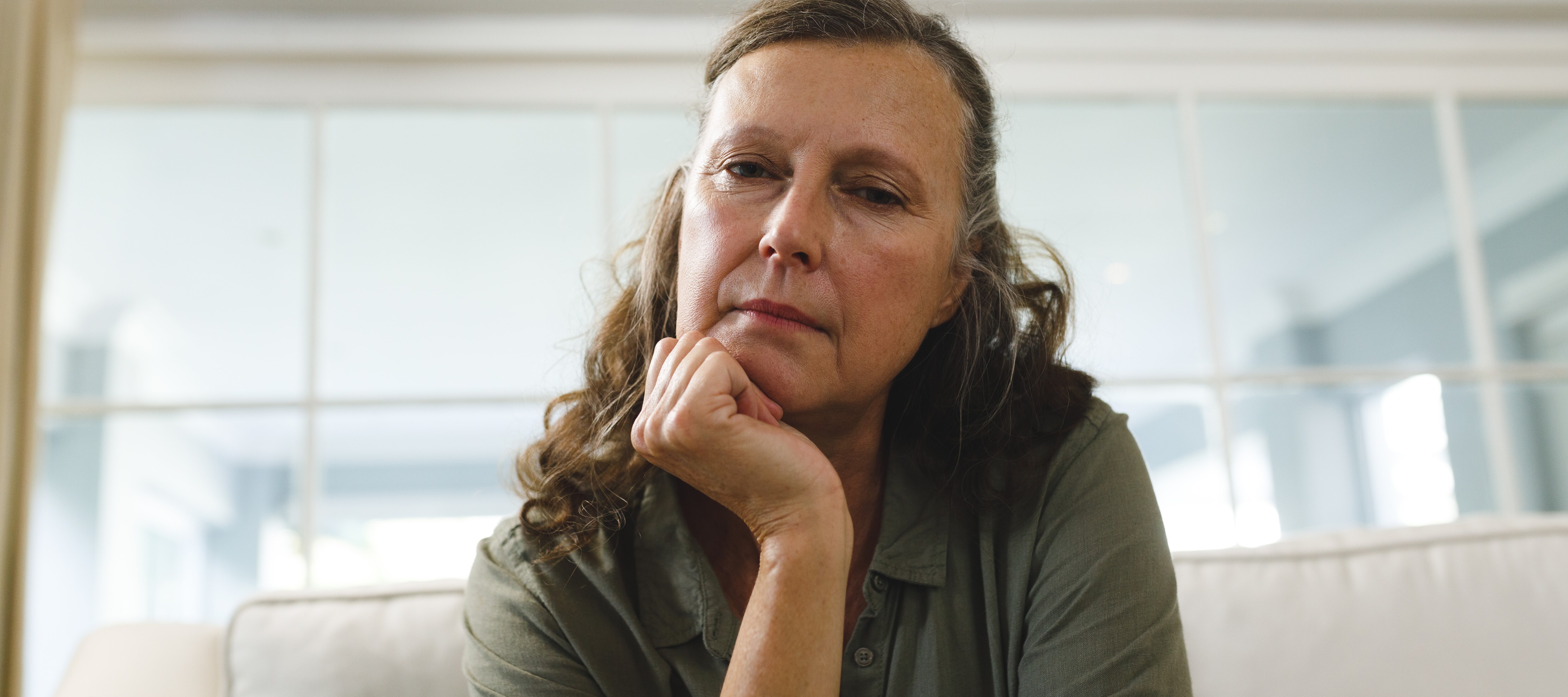 Middle aged woman looking concernedly thinking about retirement.