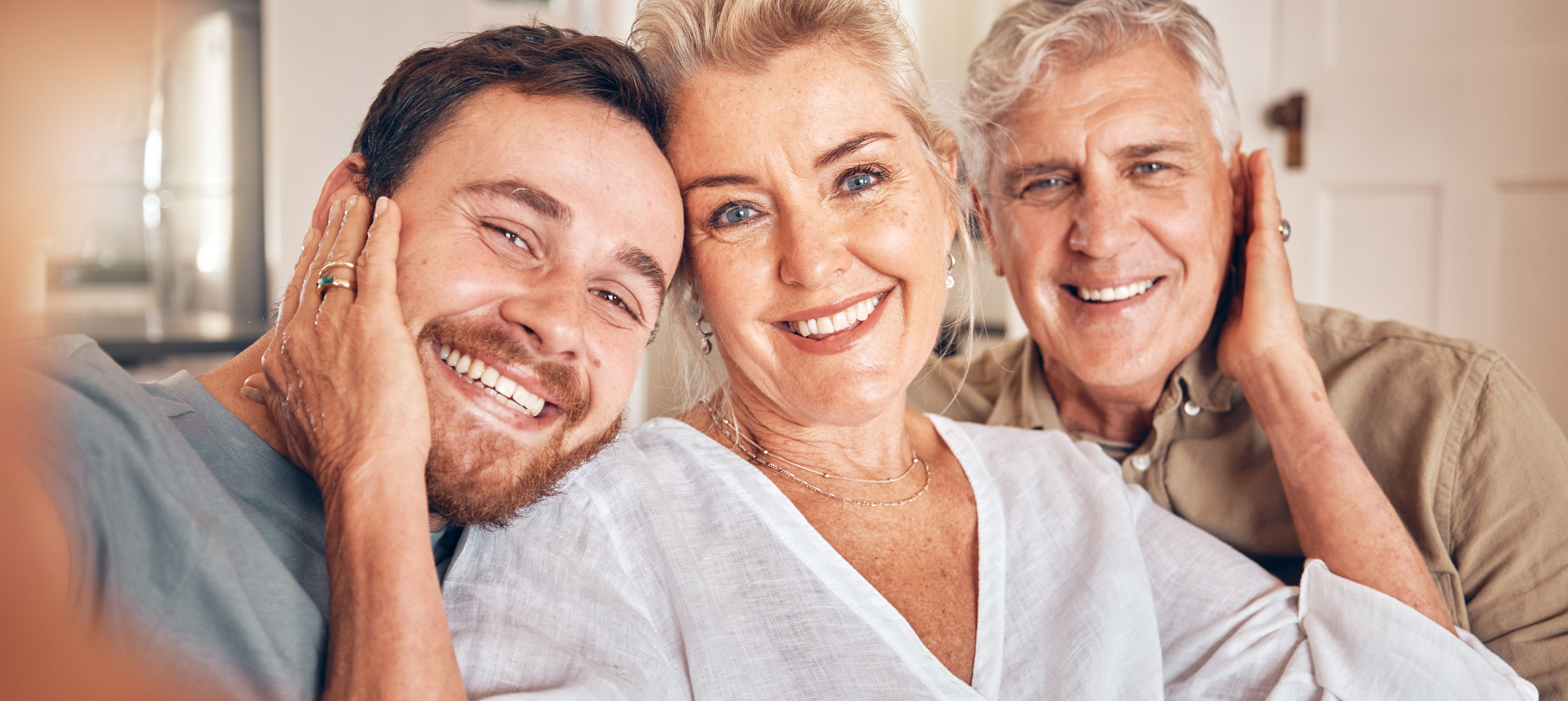 Retired parents smiling with their adult son.