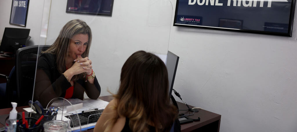 Woman speaking with a tax preparation specialist to get her taxes ready to be filed.