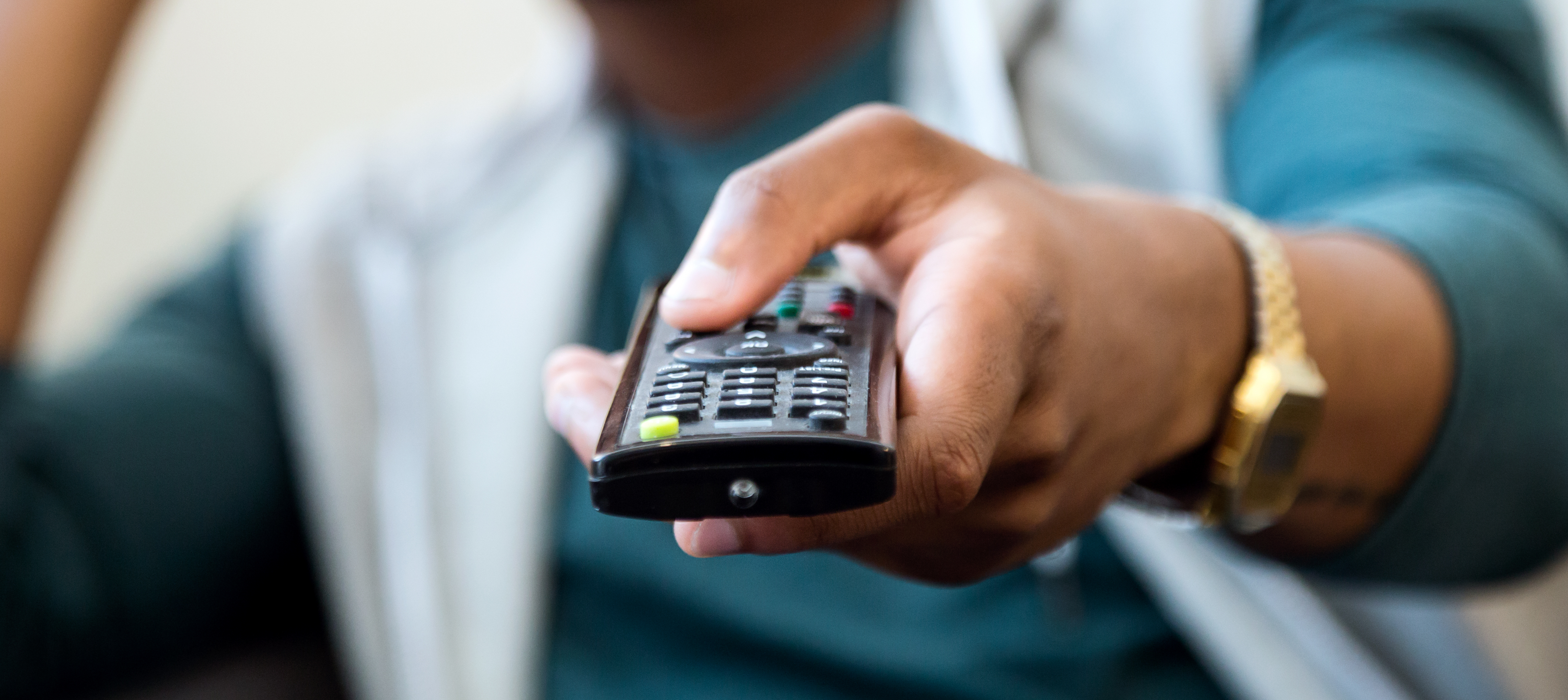 Close up of man pointing TV directly at the camera.