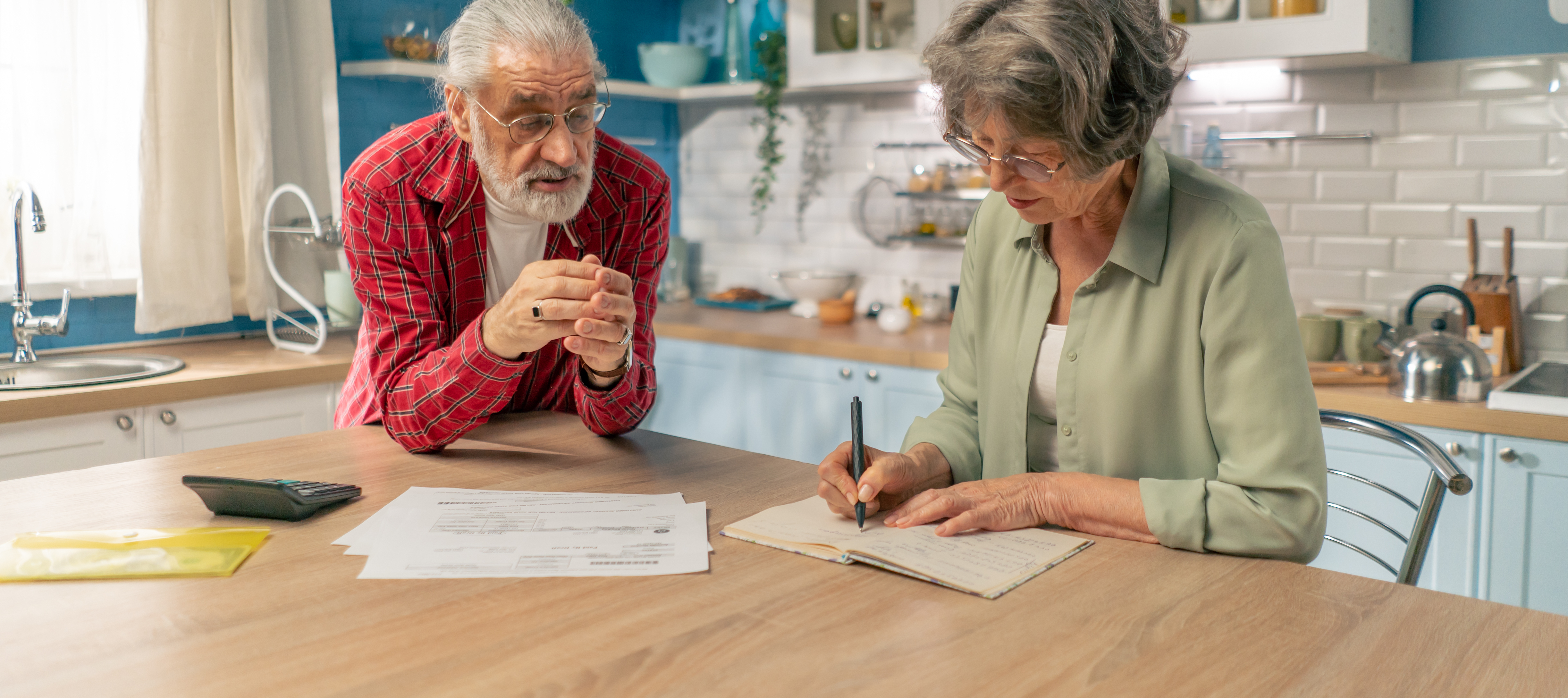 A couple looks over a few bills together.