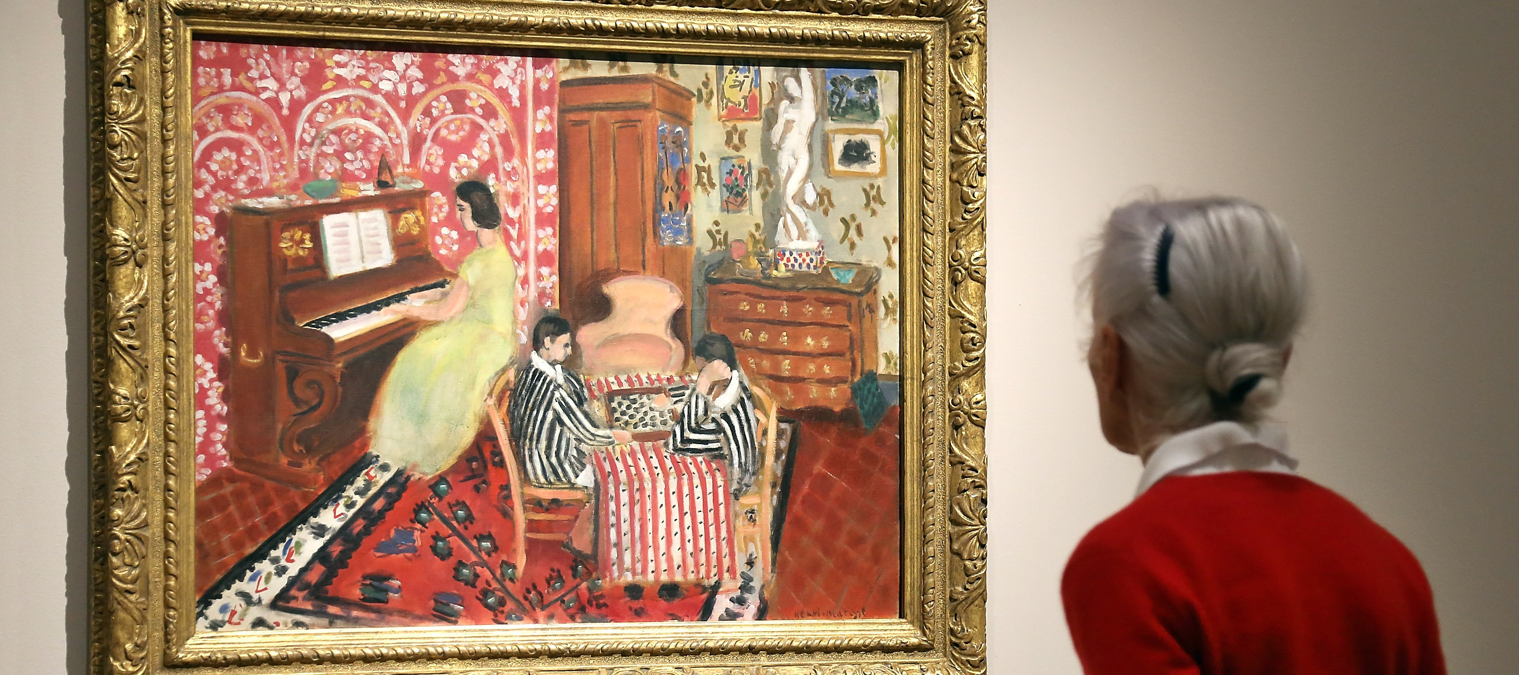 A woman looking at "Pianist and checker player," a painting by Henri Matisse.