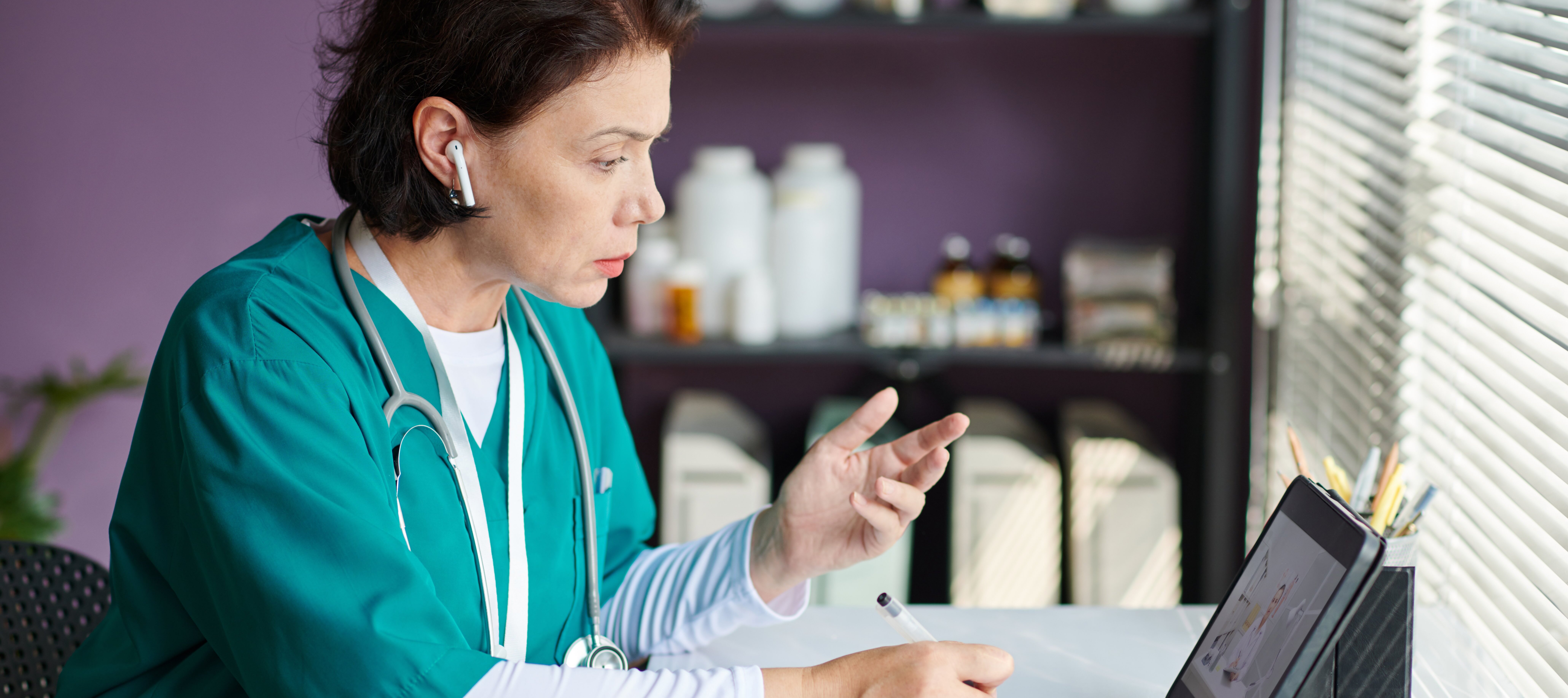Nurse conducting digital consult at her desk.