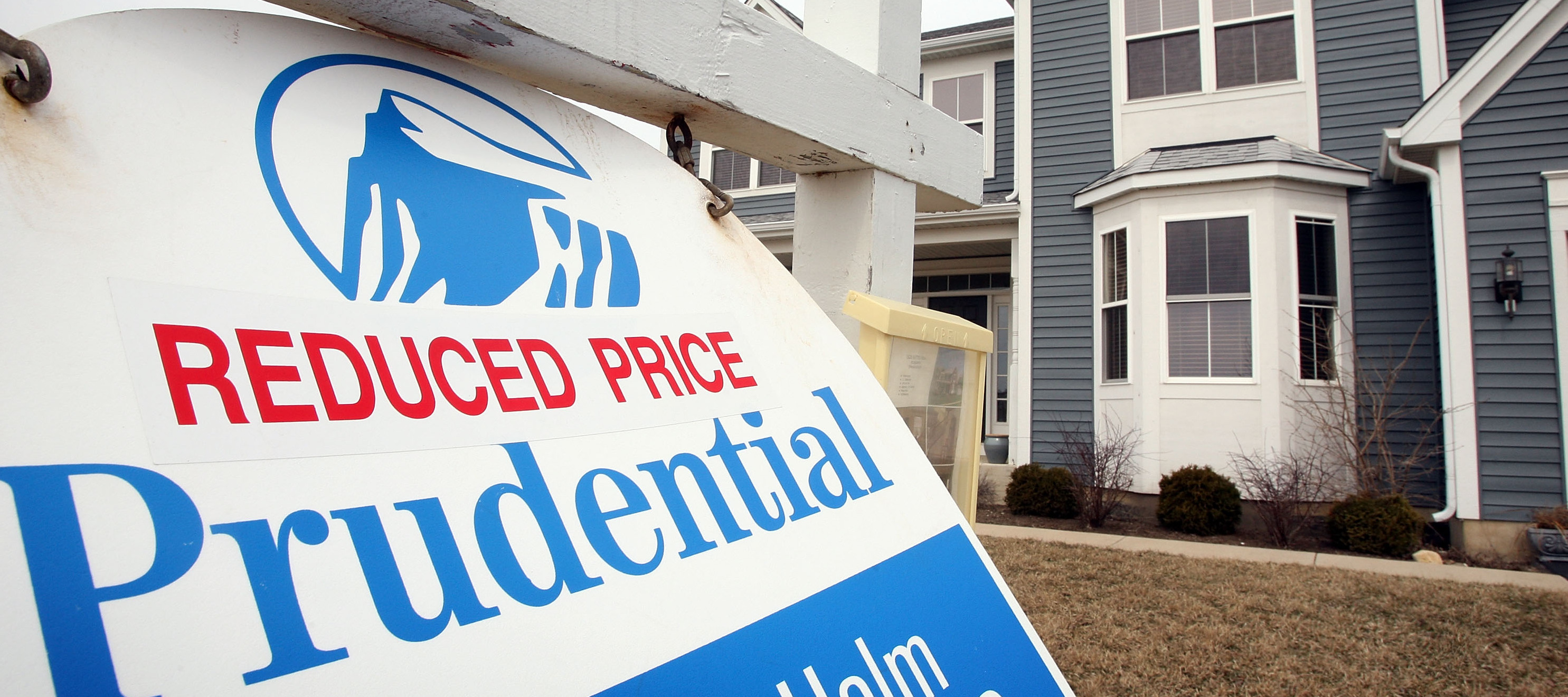 A sign reading "REDUCED PRICE" sits outside of a home in Illinois.