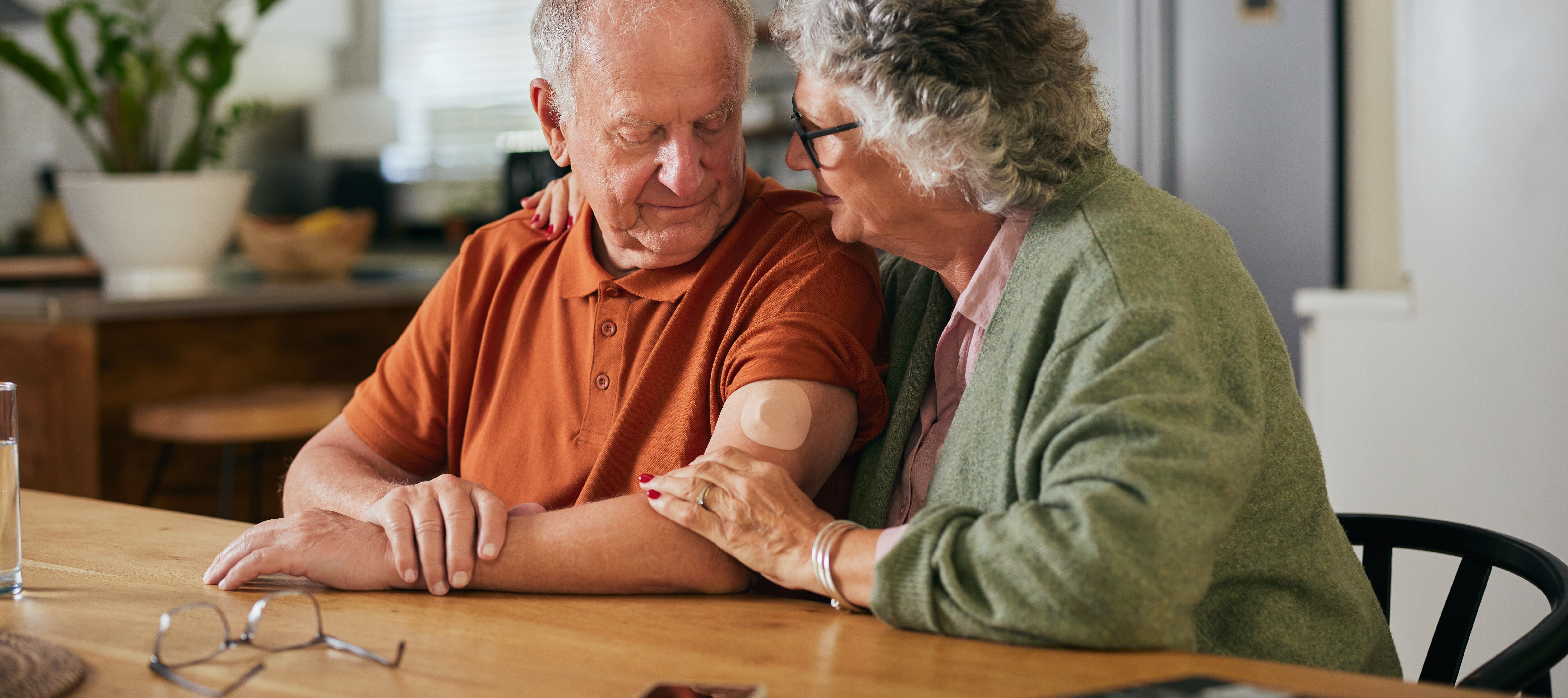 A concerned couple sits in their kitchen.