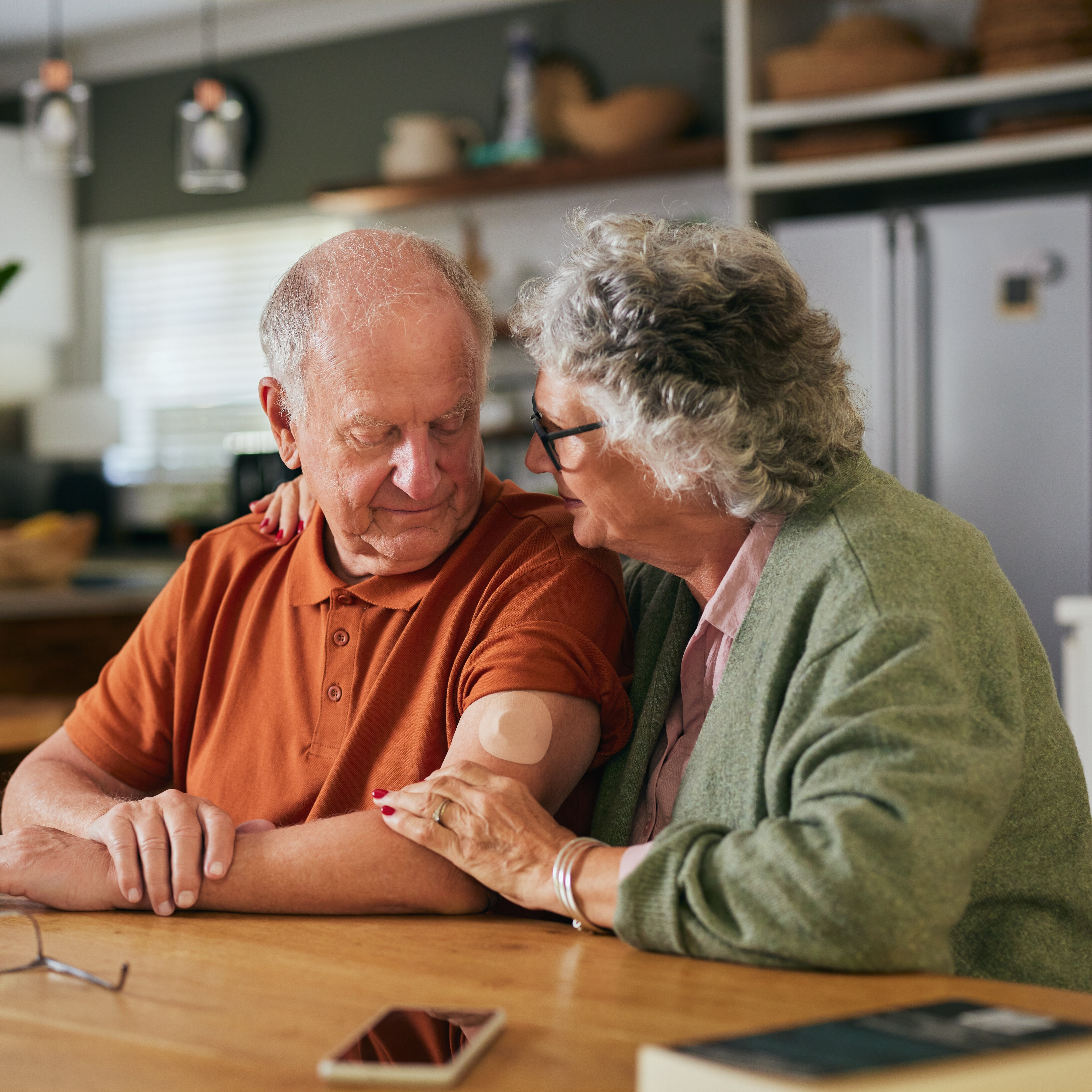 A concerned couple sits in their kitchen.