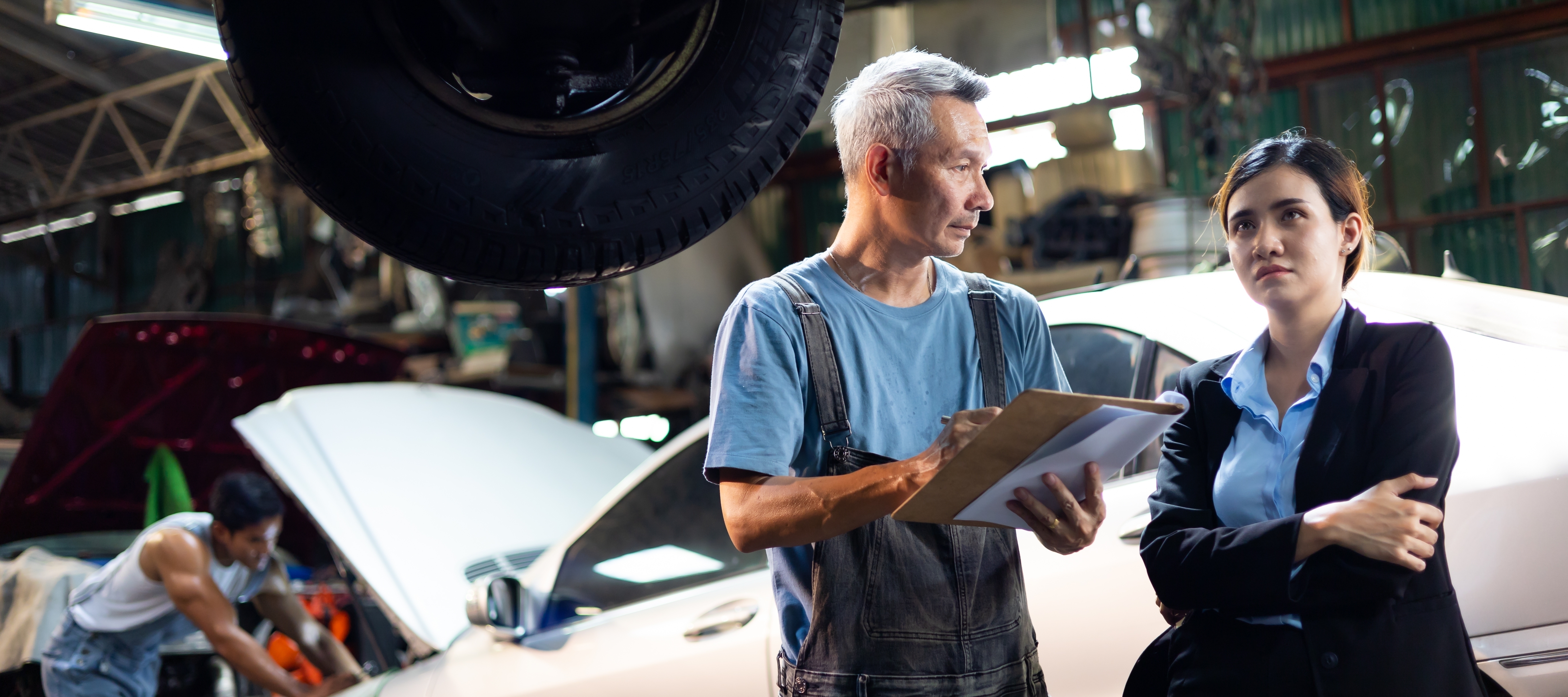A woman speaks with the mechanic.