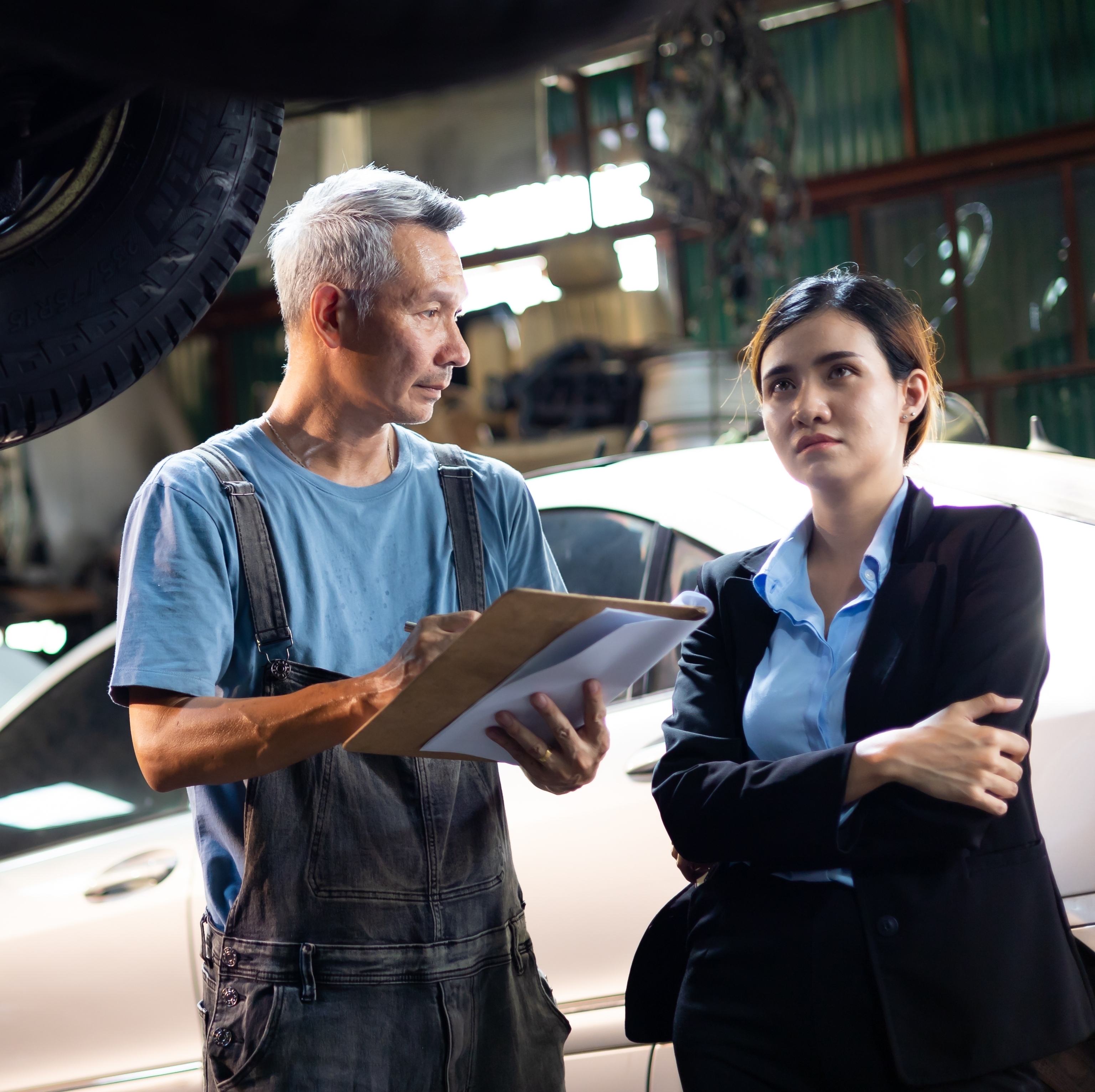 A woman speaks with the mechanic.