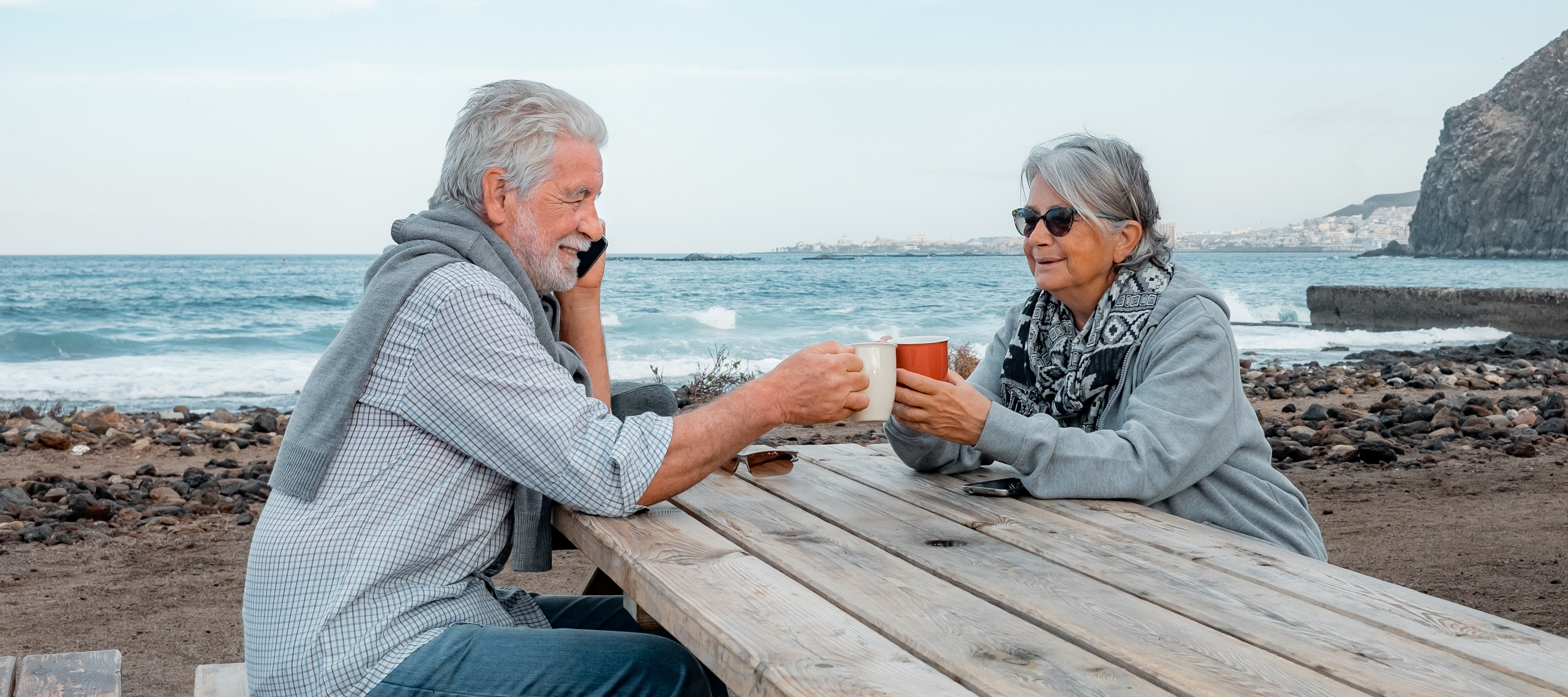 A retired couple enjoys each other's company on the beach.