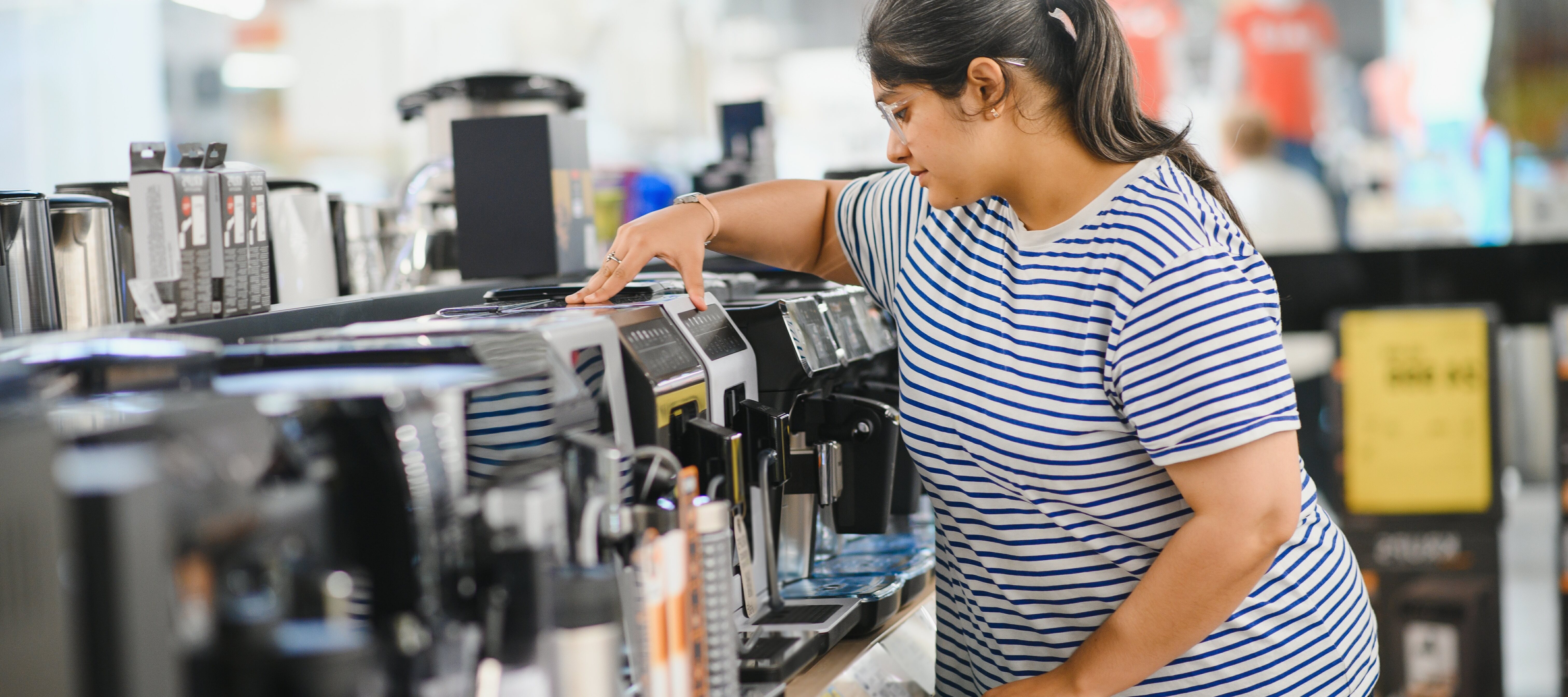 Woman choosing a coffee maker to purchase