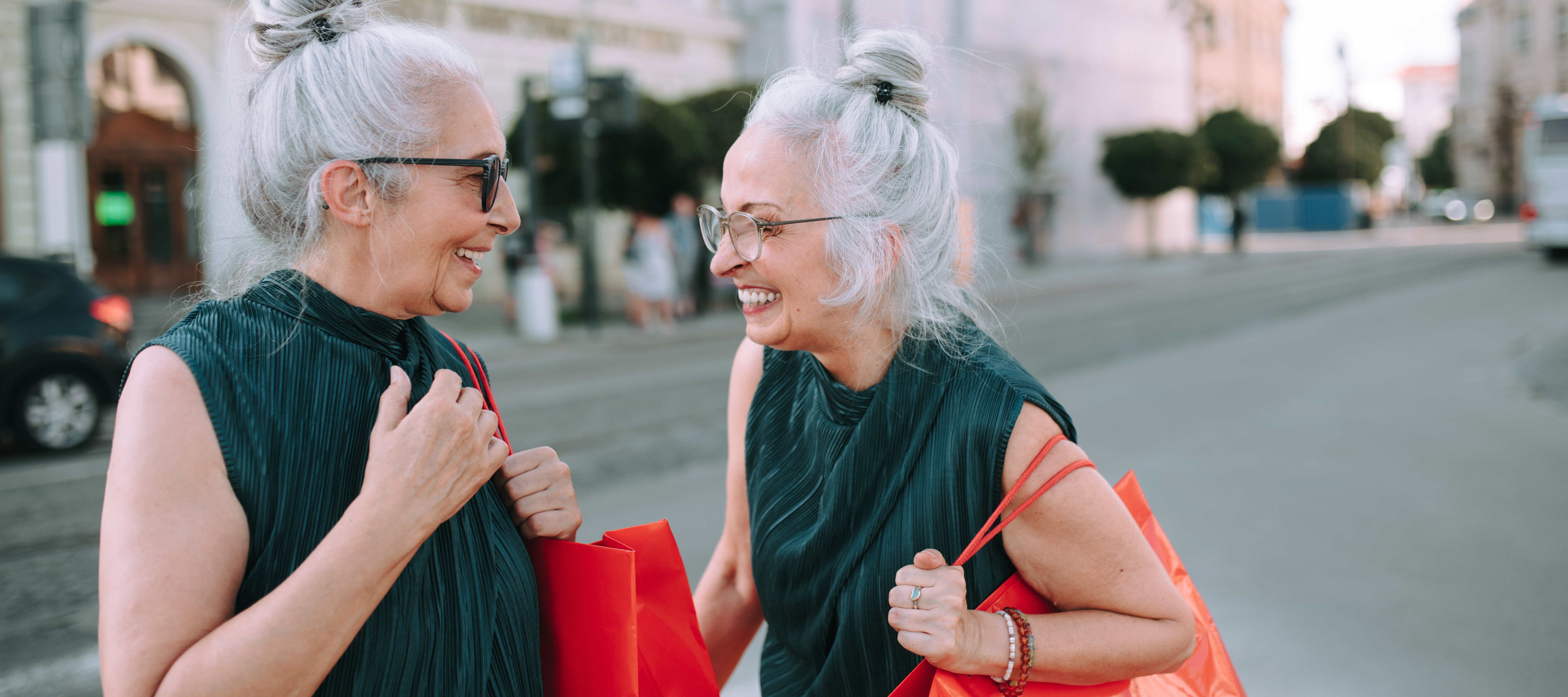 Two older women laughing and shopping.