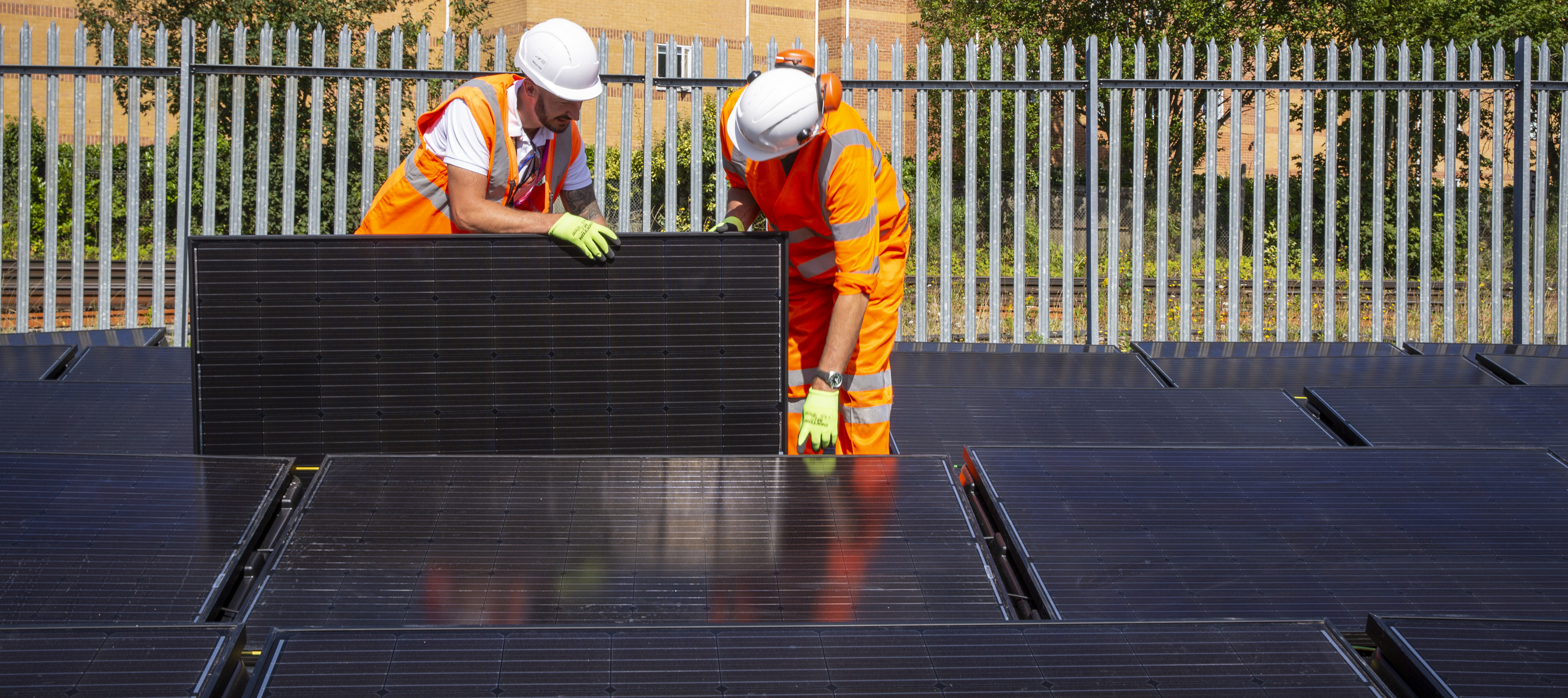 Two workers installing solar panels.