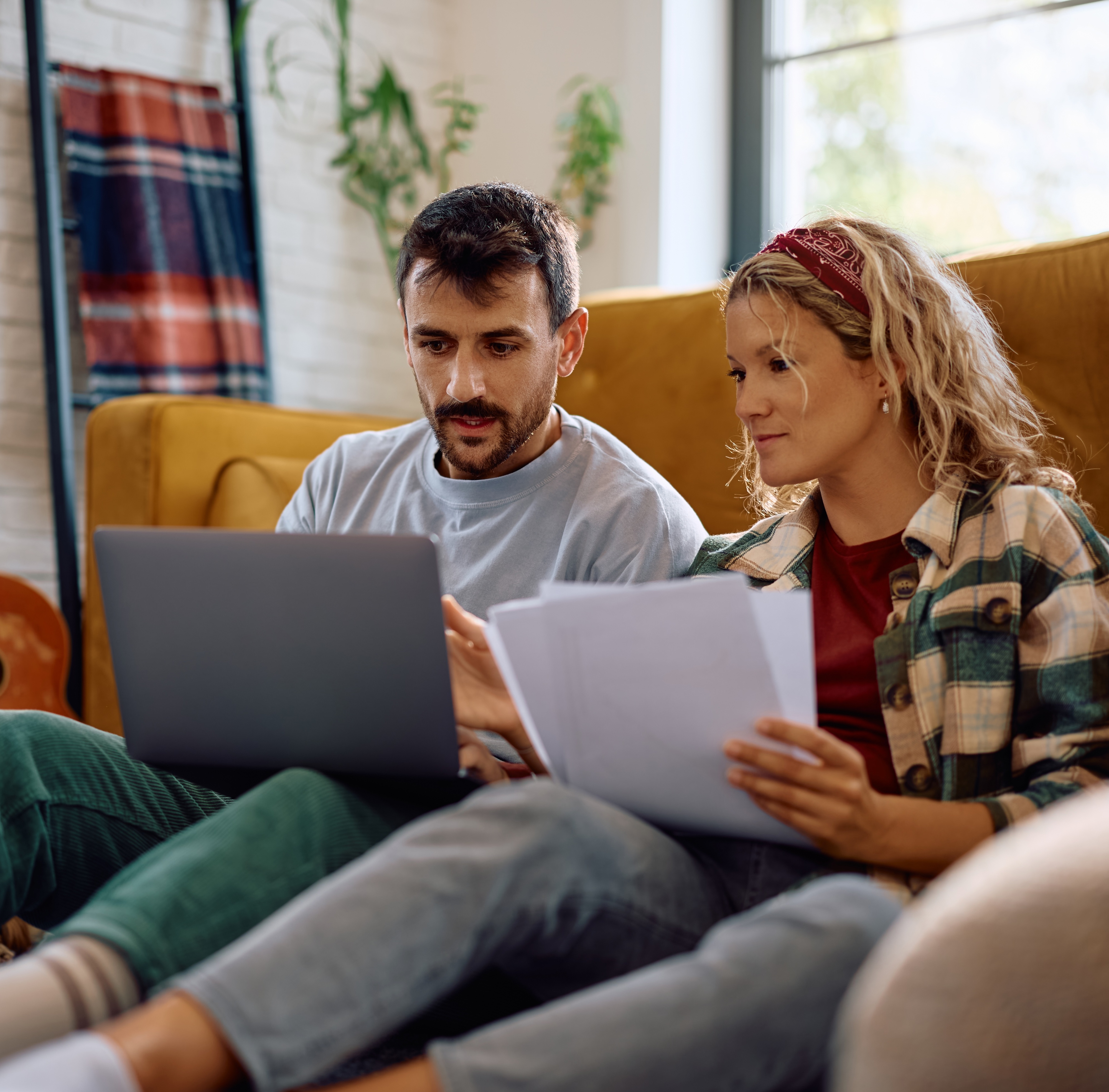 Young couple looking at credit reports and bills together.