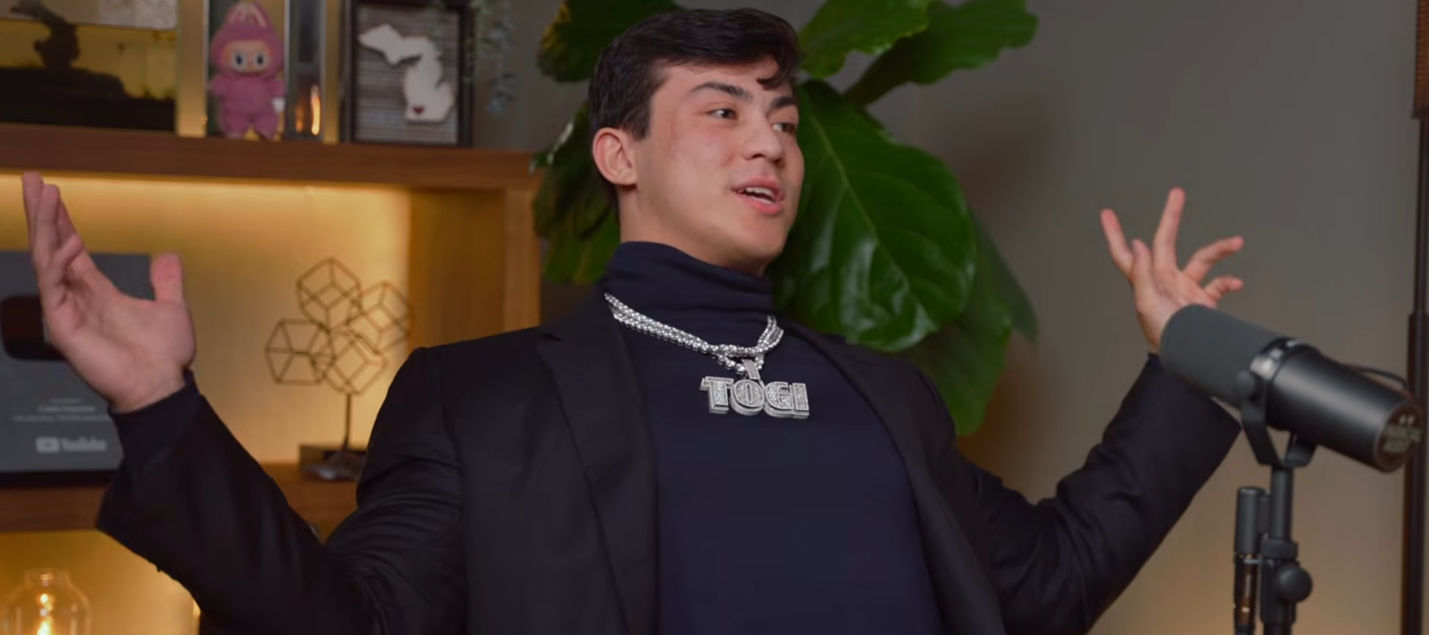 Gymtoker and YouTuber Togi spreads out his arms in an episode of The Iced Coffee Hour.