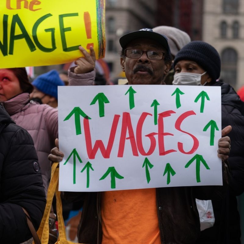 Mayor Zohran Mamdani and a man holding a protest sign