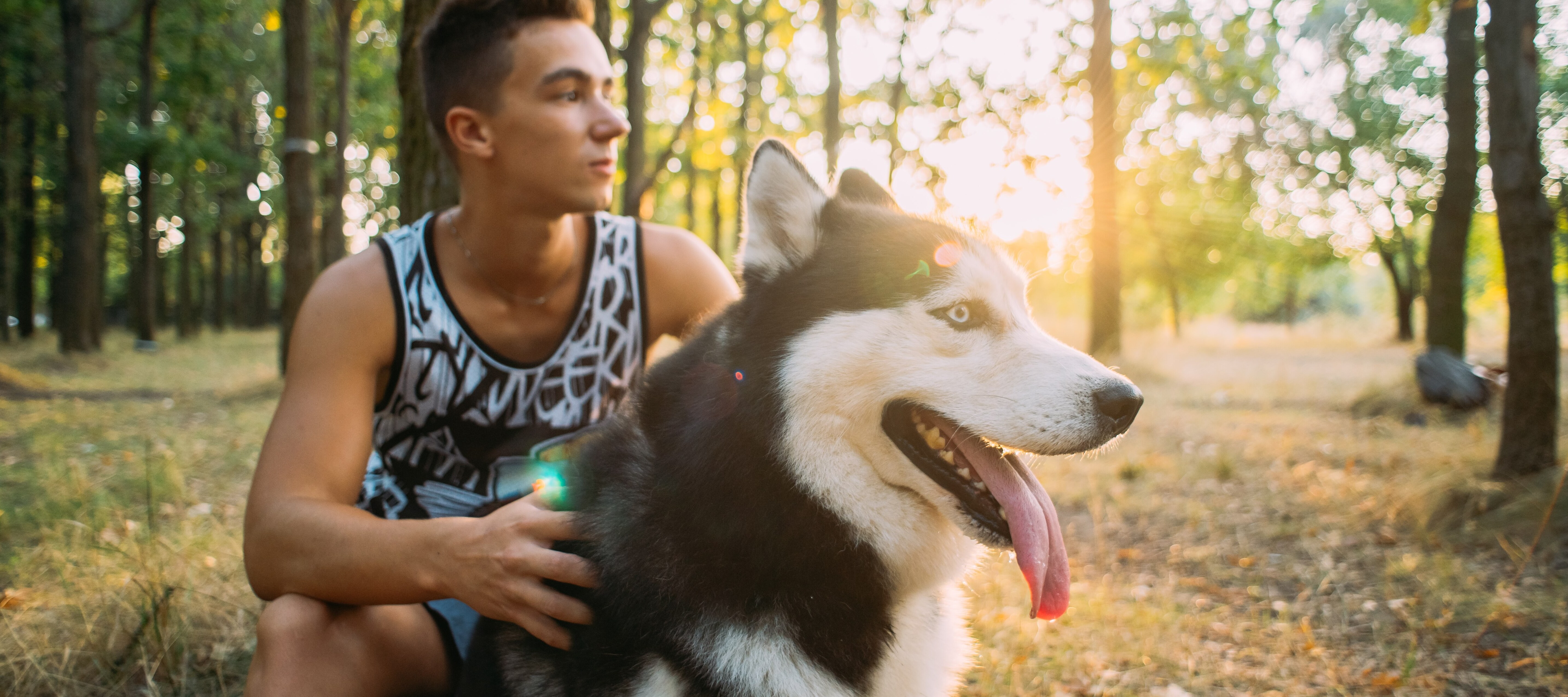 A young man, holding onto his Siberian husky while on a walk, can be one of many Americans choosing to give up their pets in order to afford rent or mortgage.