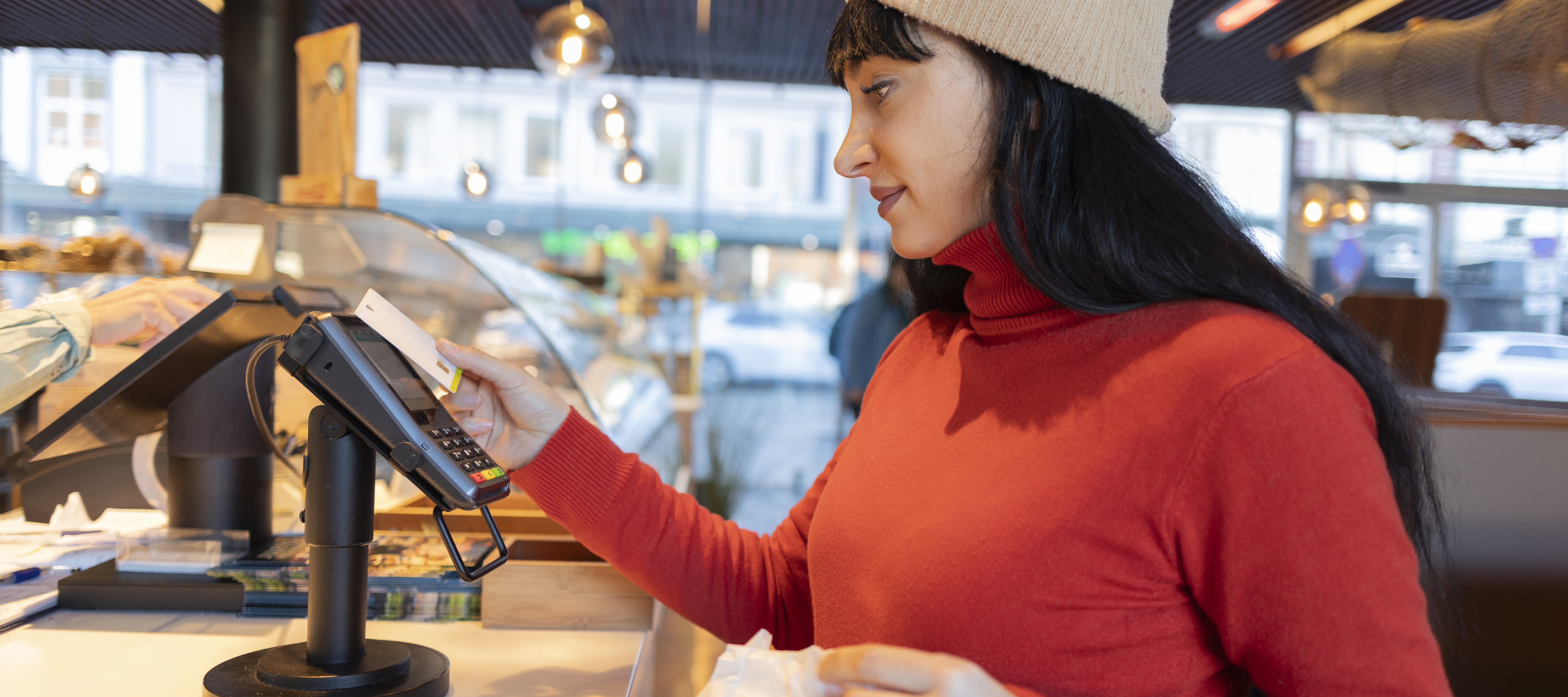 Young woman purchasing expensive treats at bakery.