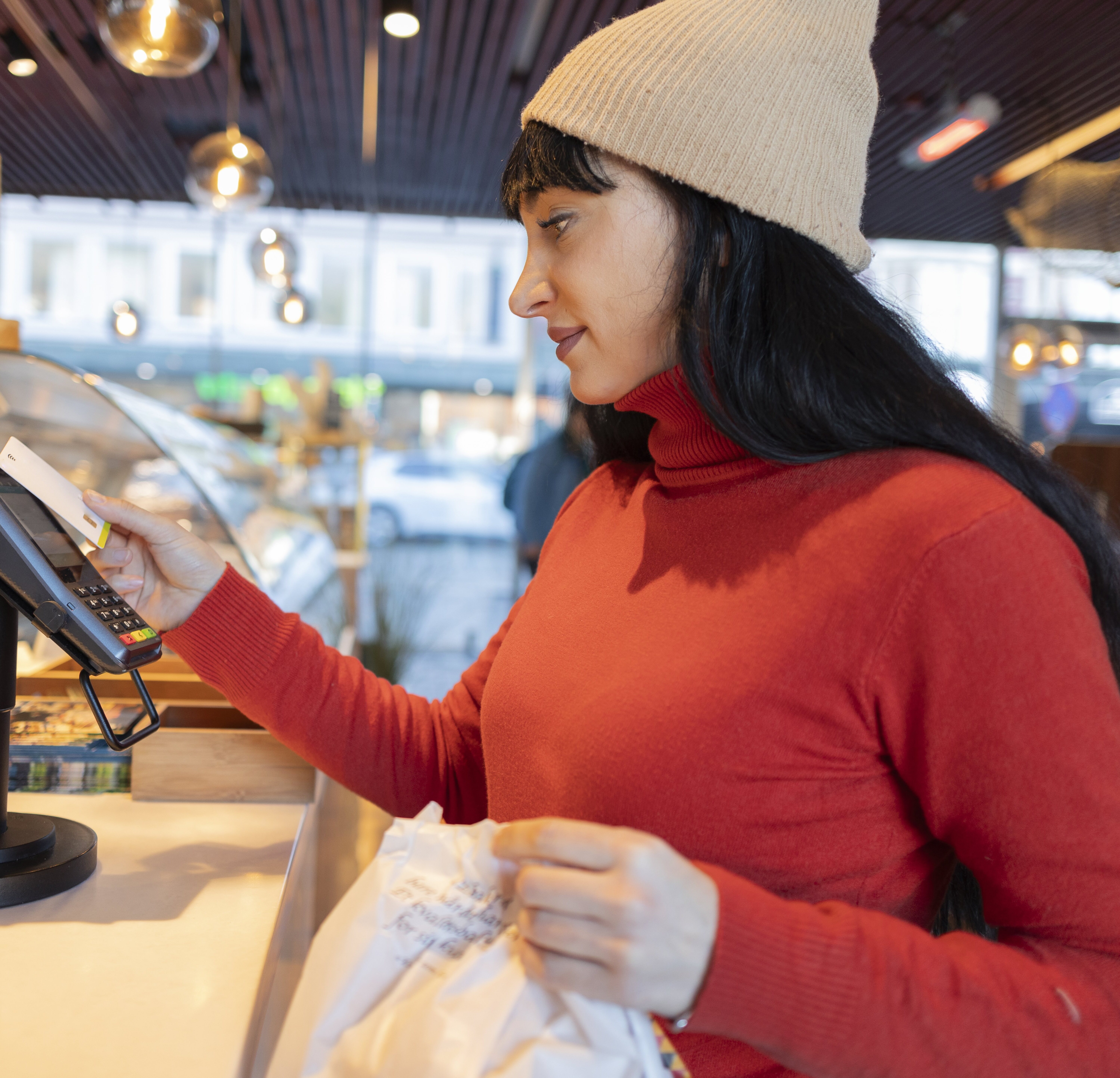 Young woman purchasing expensive treats at bakery.