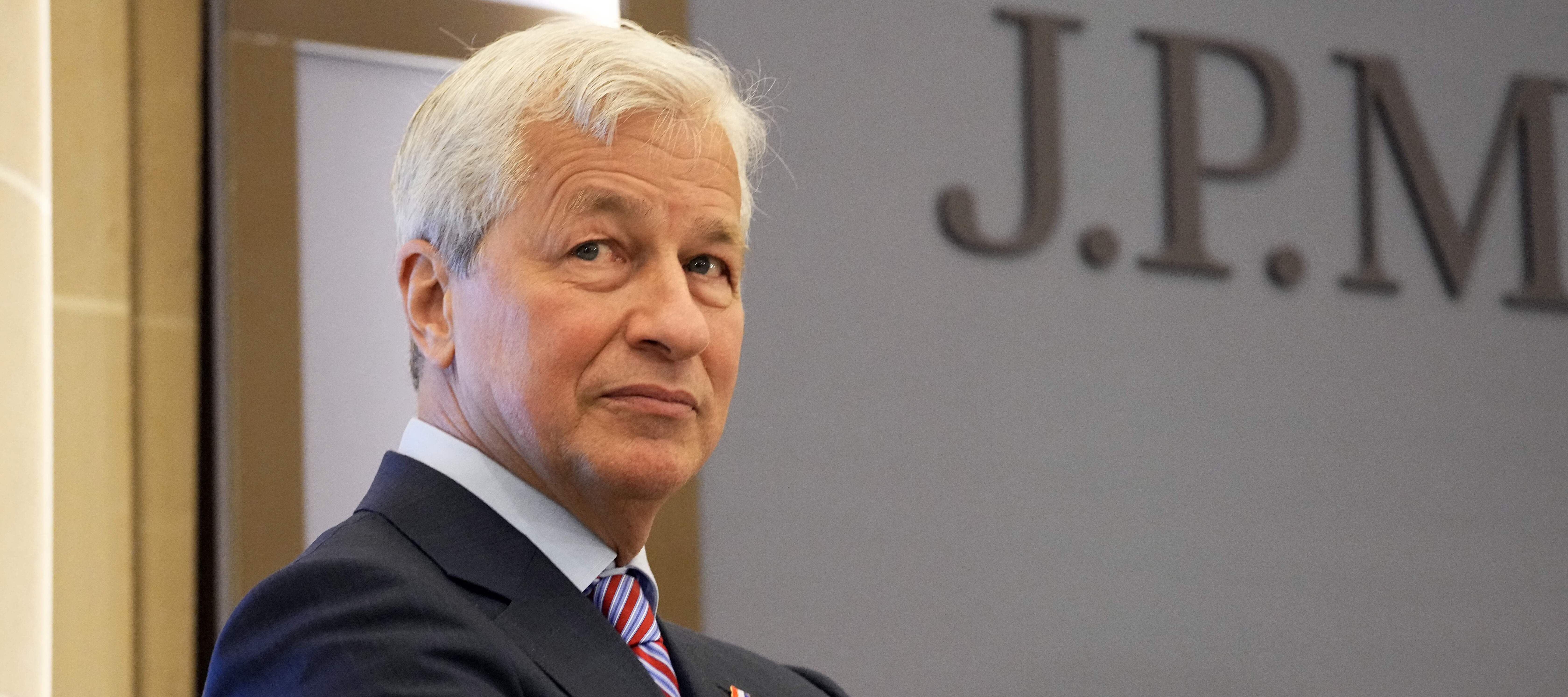 Jamie Dimon stands with his arms crossed, looking over his right shoulder.