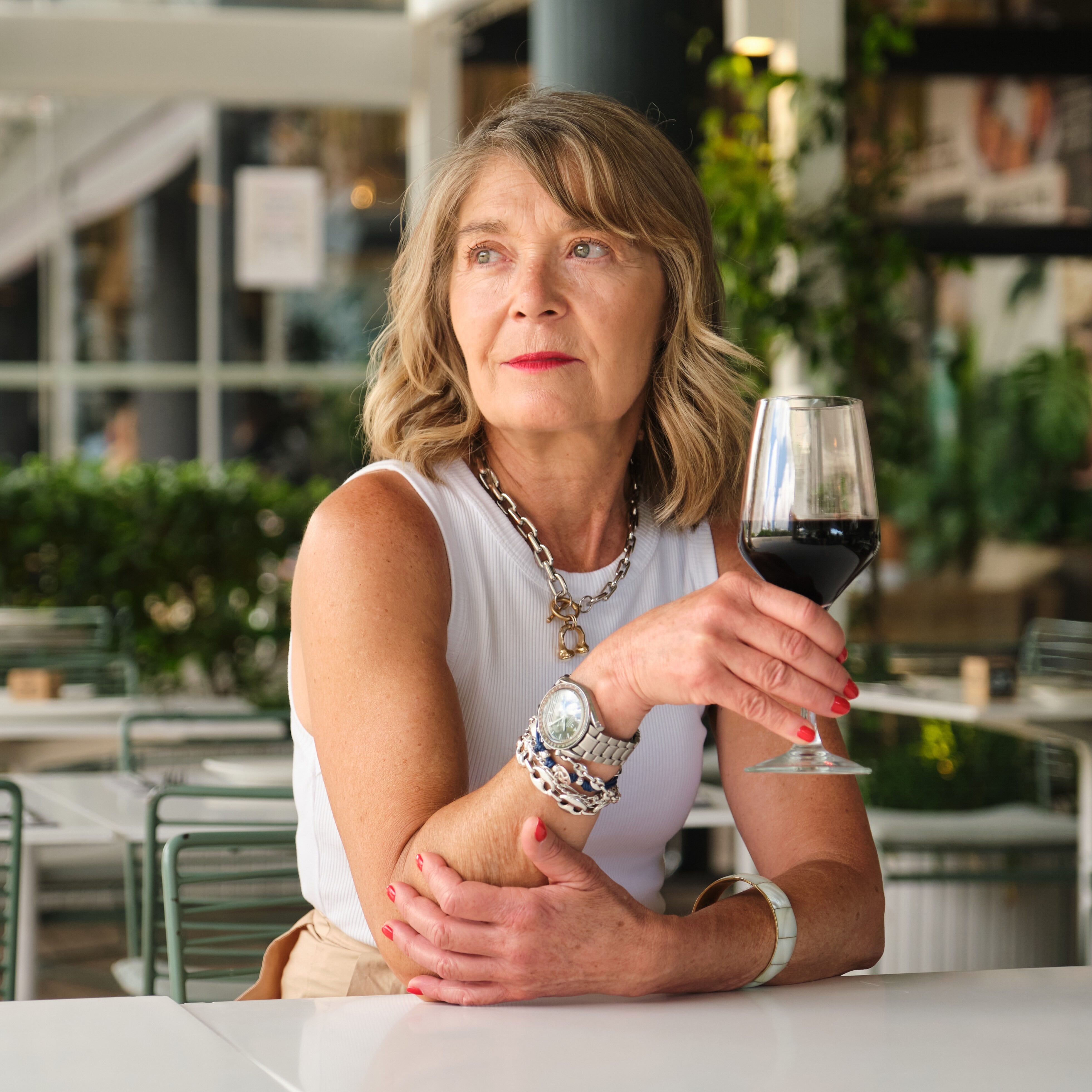 Older divorced woman drinking red wine.