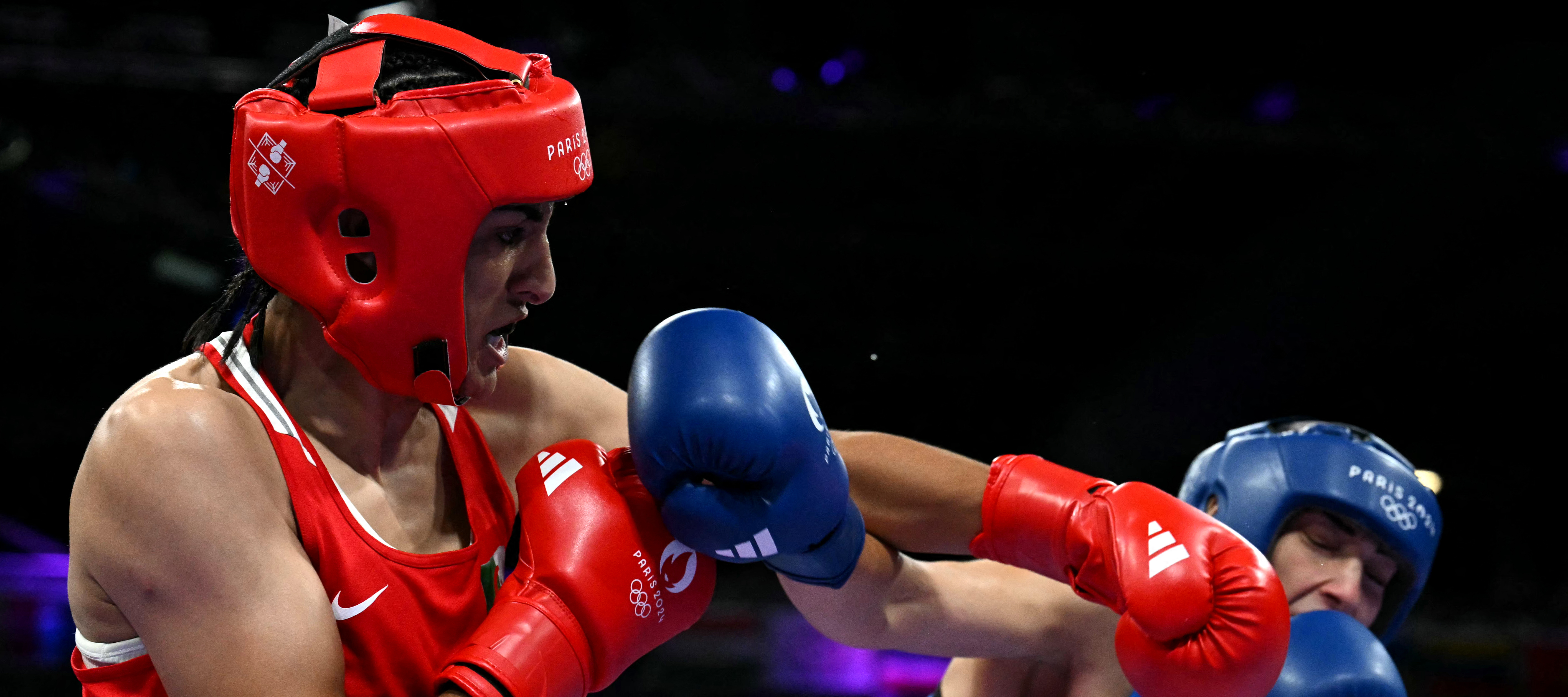 A photo of two boxers, one in red and one in blue sparring in the ring.