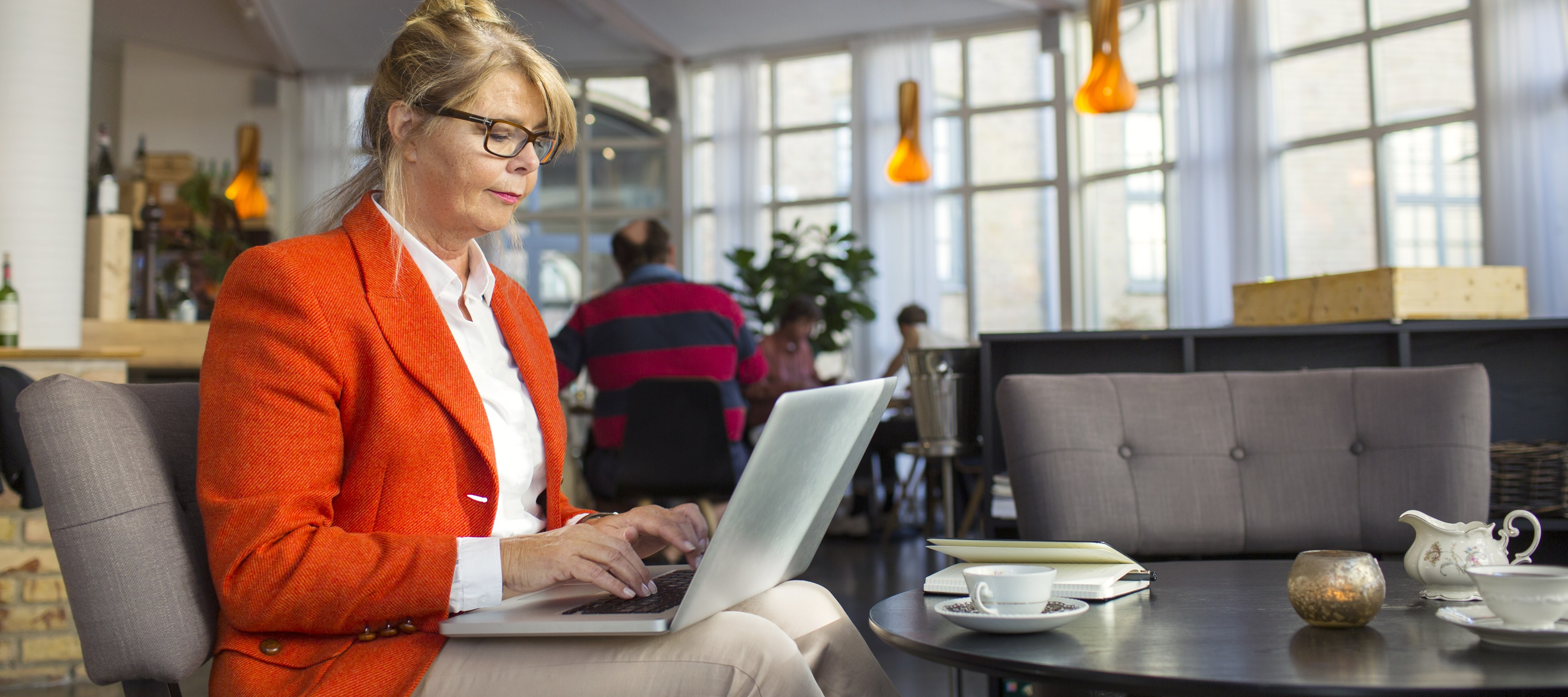 Retired woman in her 60s doing work at a coffee shop