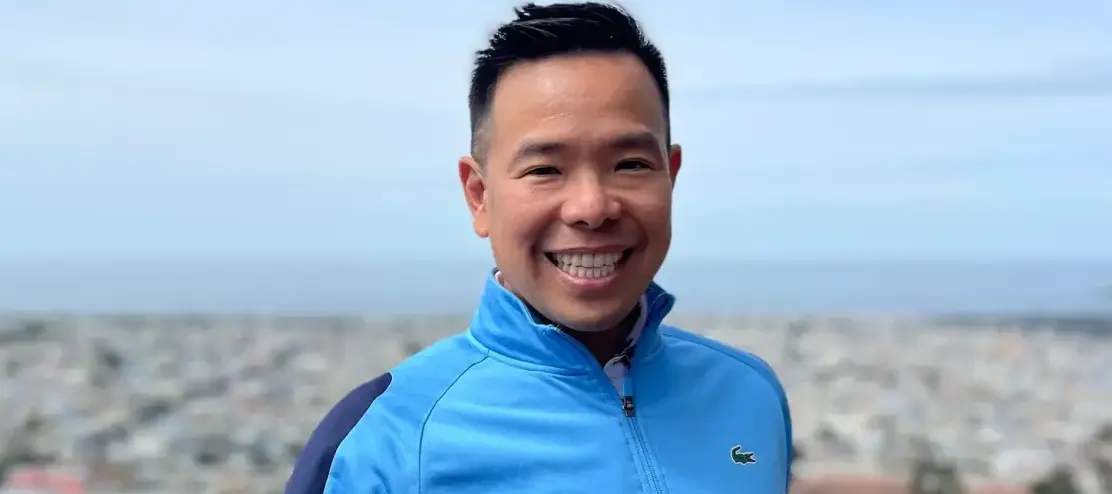 Sam Dogon, known online as The Financial Samurai, smiles at the camera in a blue wind breaker.
