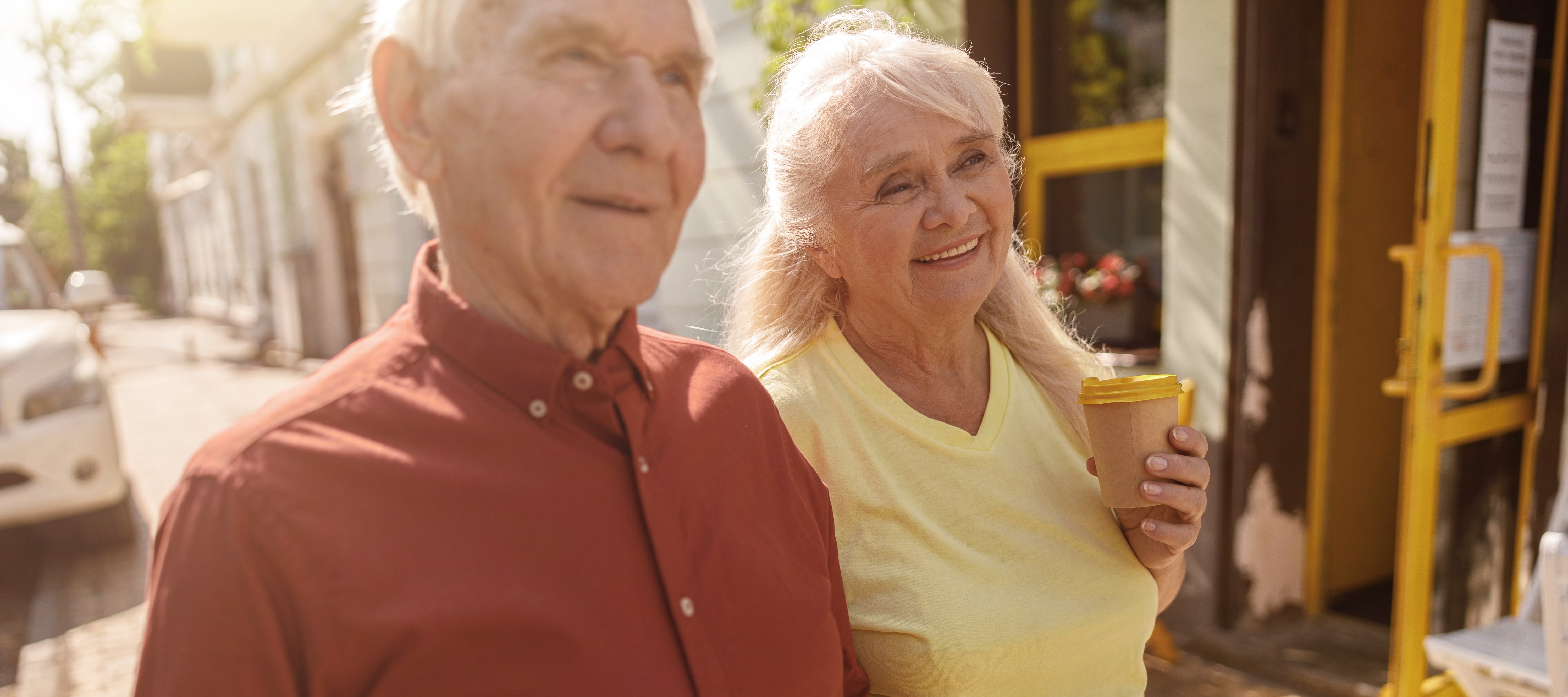 Retired couple enjoying coffee on a walk.