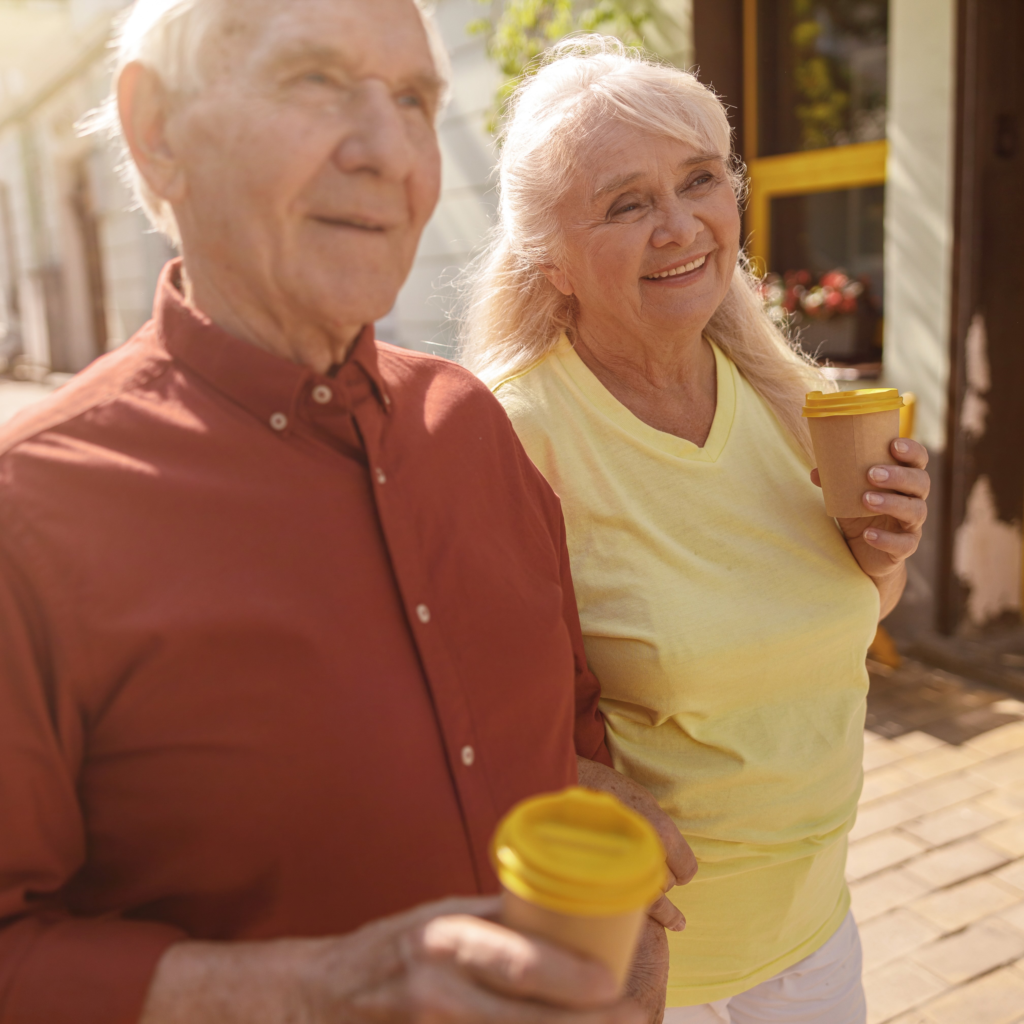 Retired couple enjoying coffee on a walk.