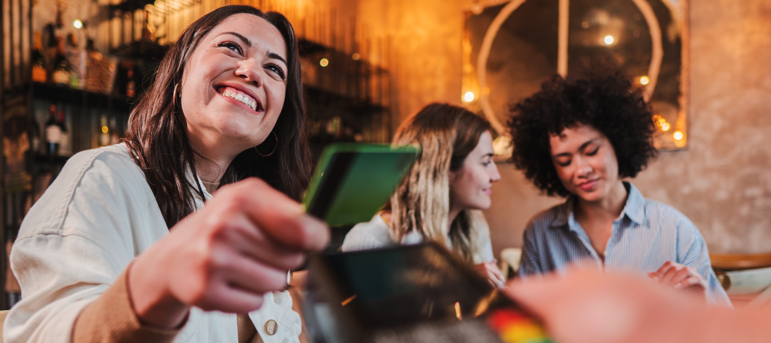 A young woman is paying for her bill with a credit card.